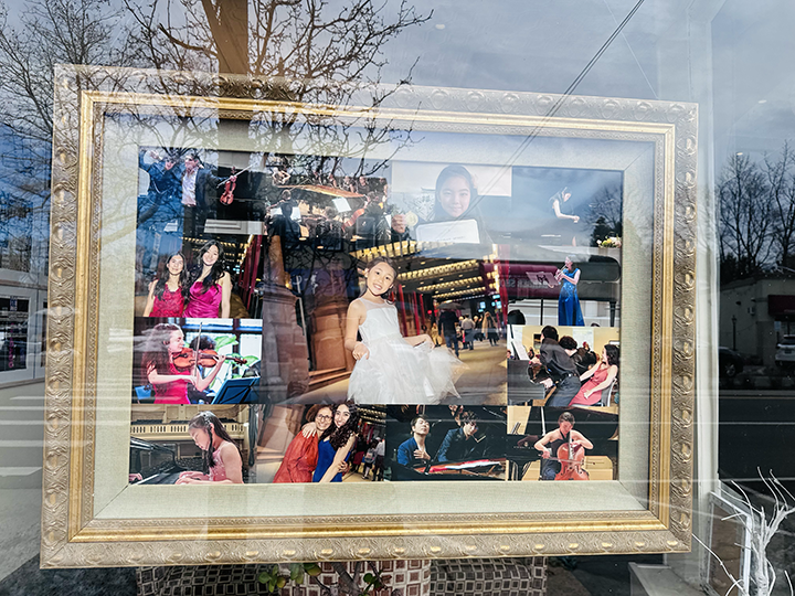 Display window featuring a collage of photos of children and young girls playing musical instruments and posing, with a decorative gold frame around the collage.