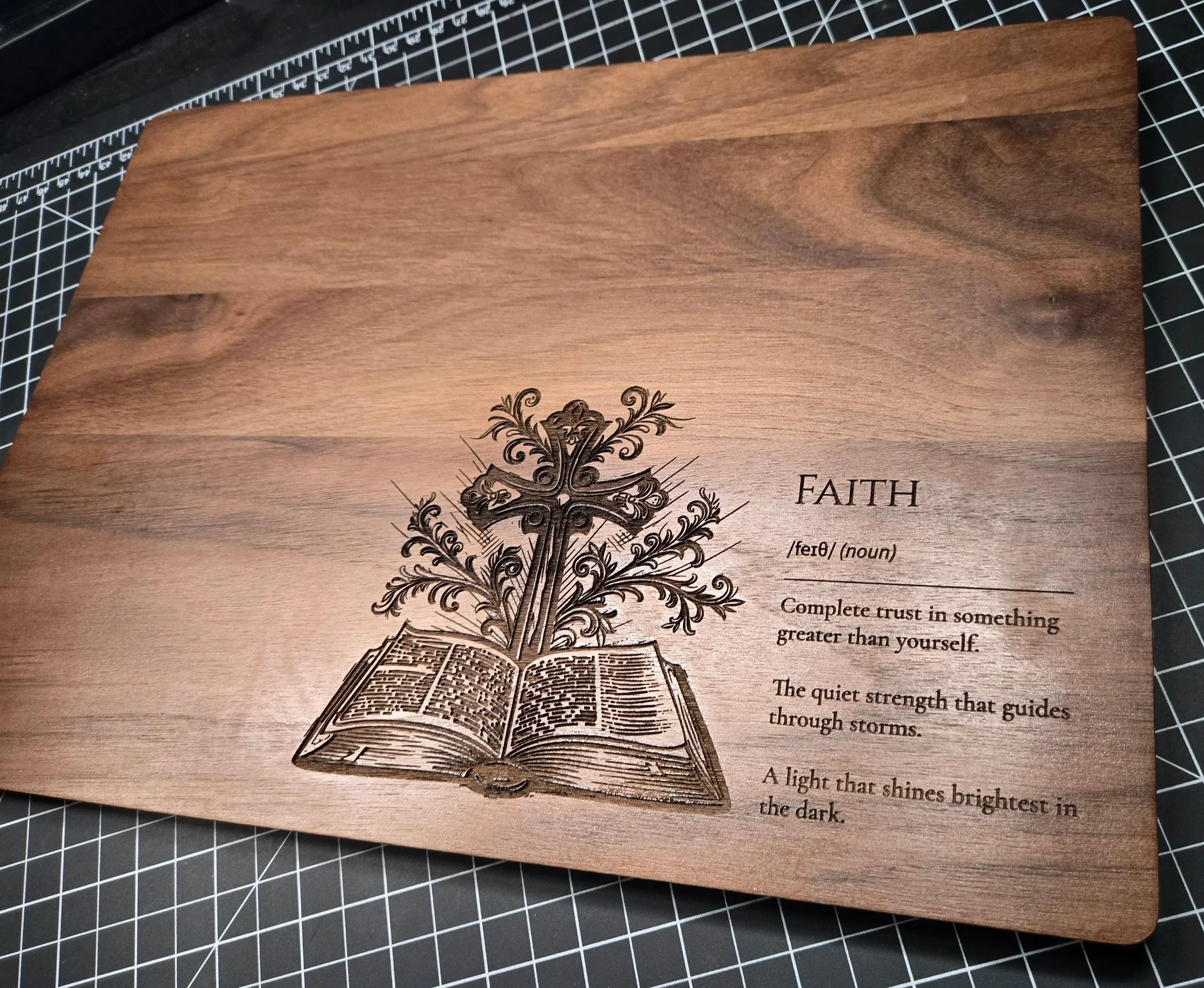 Wooden plaque engraved with the word 'Faith,' a decorative cross, and a Bible, accompanied by a definition of faith.