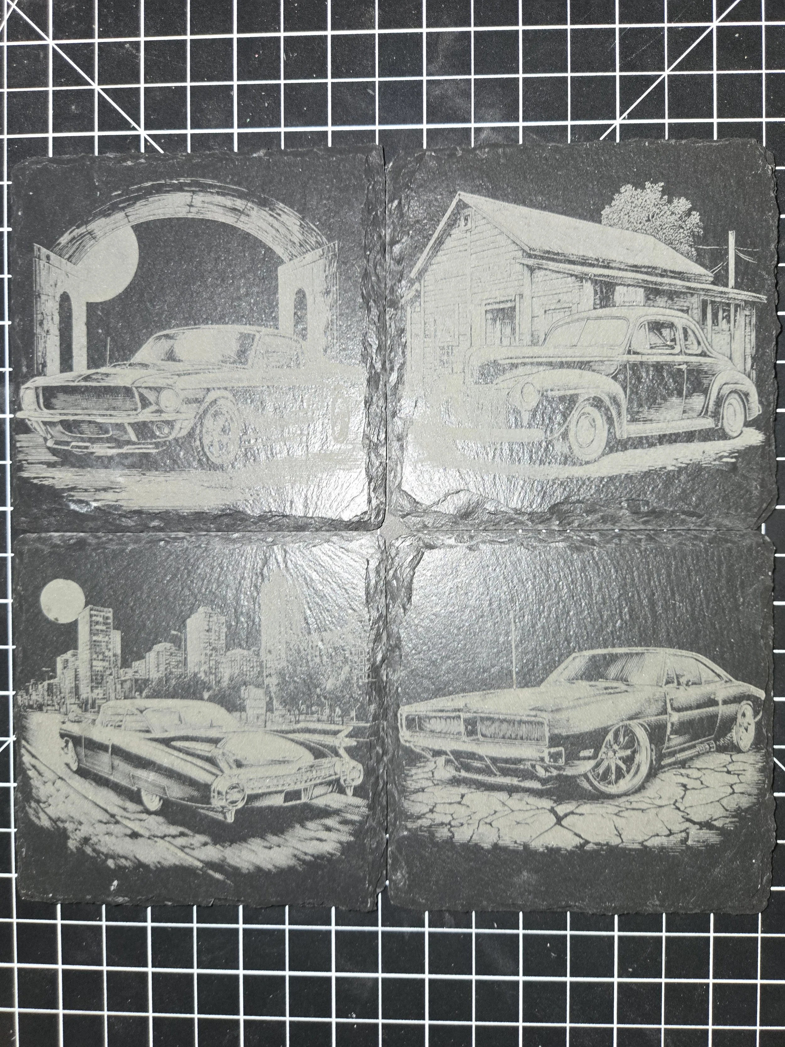 Set of four black and white engraved cards featuring classic cars in different scenes, arranged in a 2x2 grid on a cutting mat.