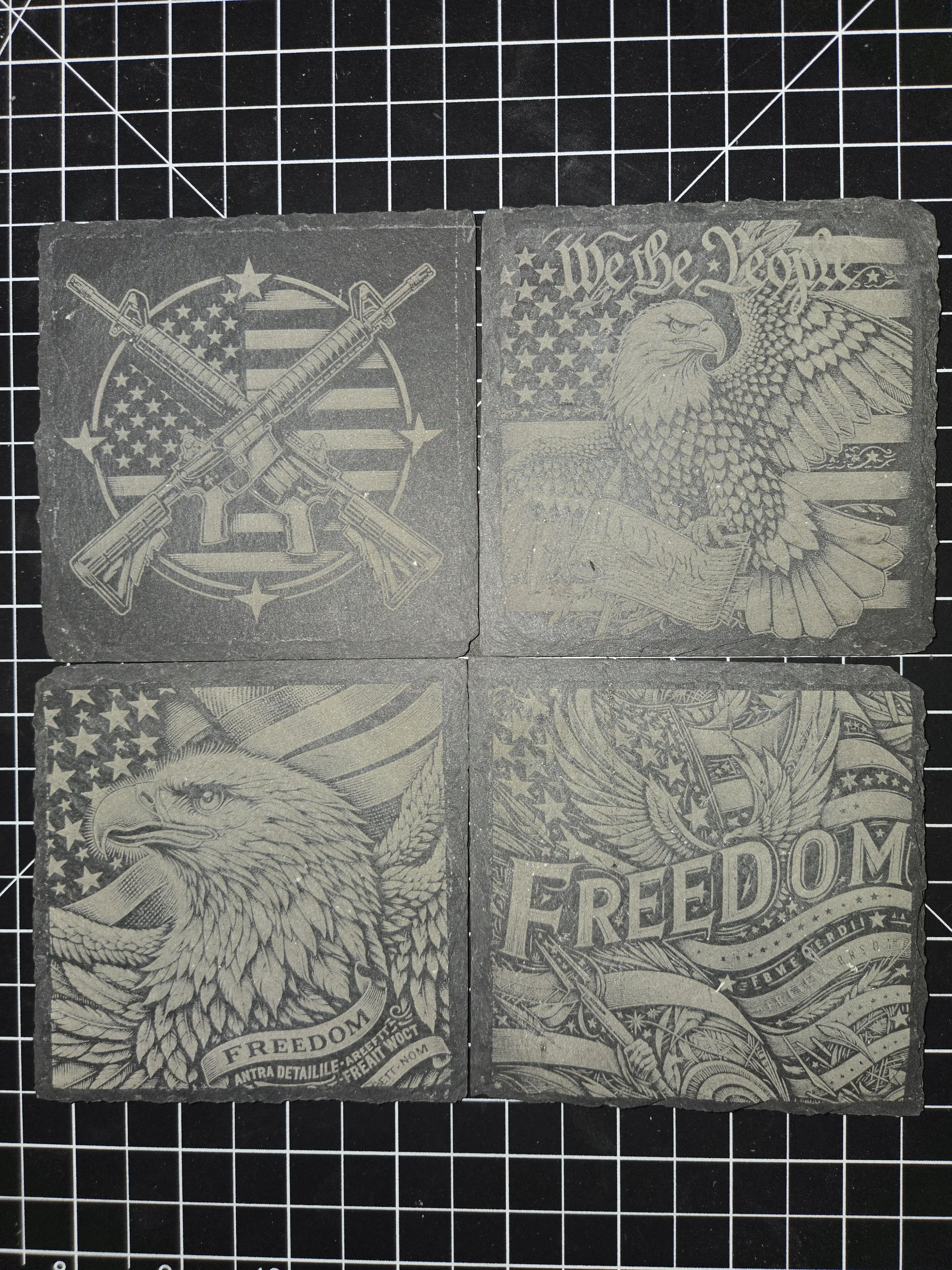Four square metal plates with engraved patriotic and political designs, including guns, eagles, American flags, and the word "FREEDOM".