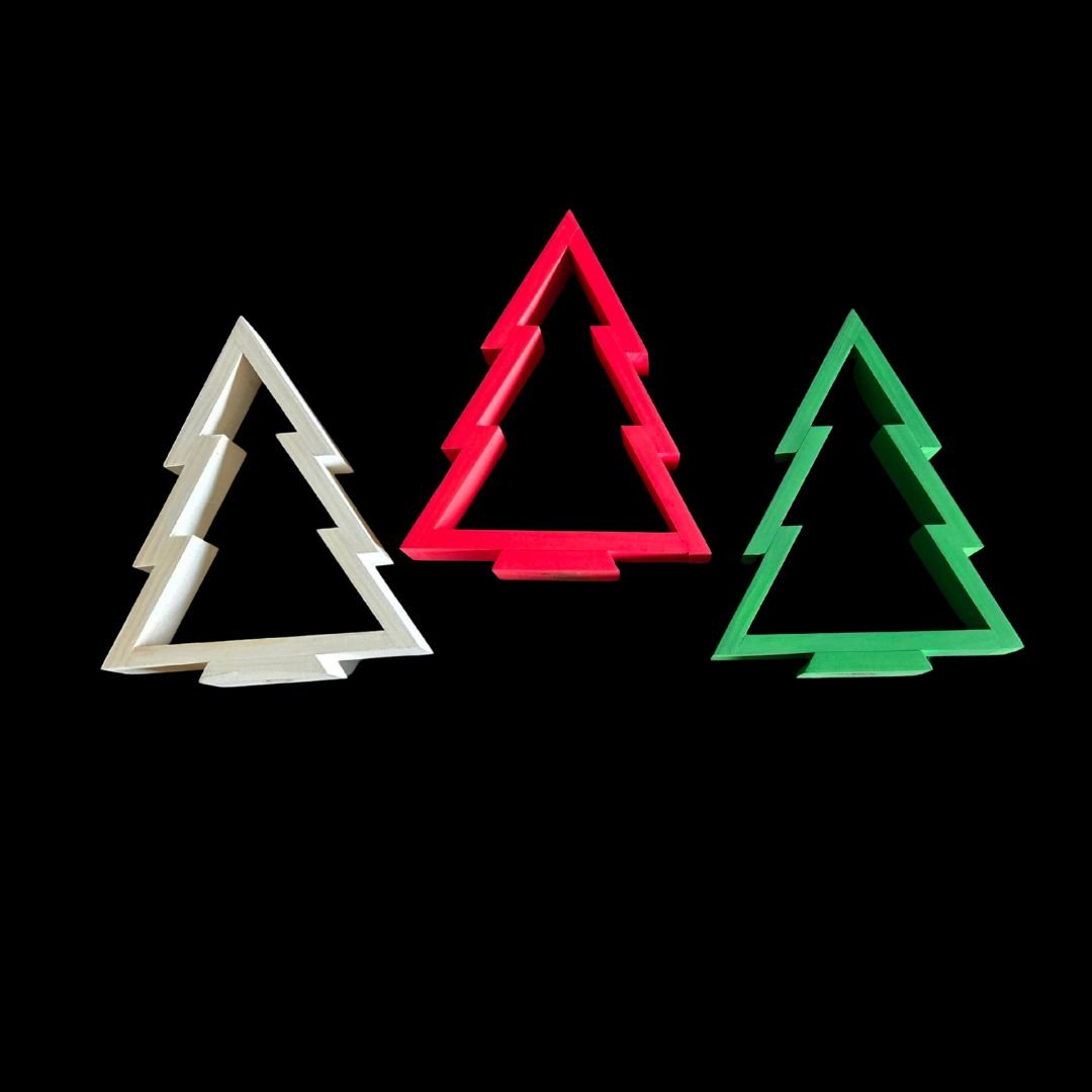 Three Christmas tree-shaped cookie cutters in white, red, and green on a black background.