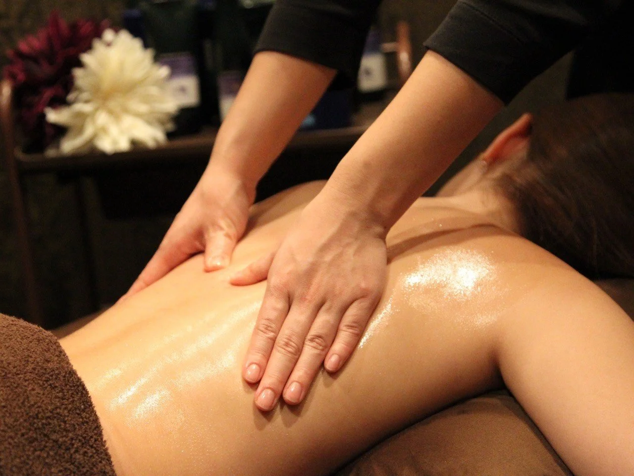 マッサージ師が背中をマッサージしている場面.