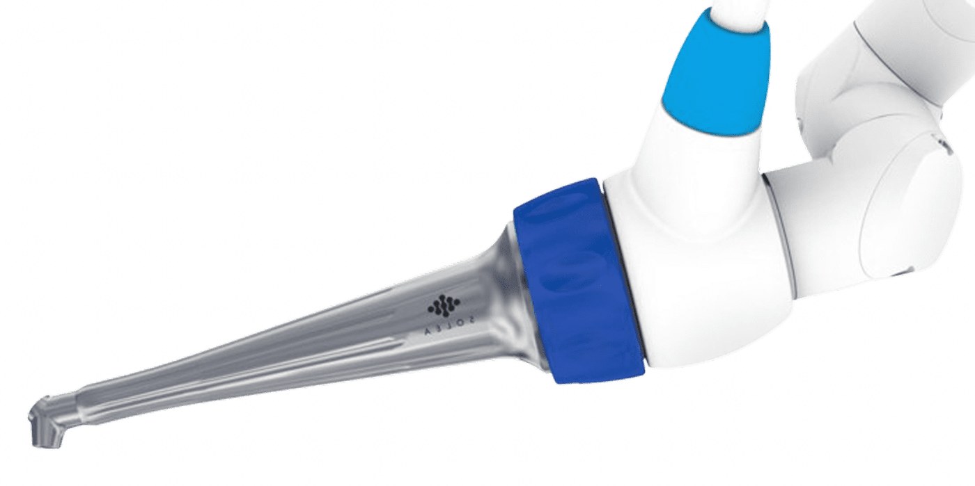 Close-up of a robotic arm with a metal nozzle, part of a 3D printer or manufacturing robot, set against a black background with small white specks.