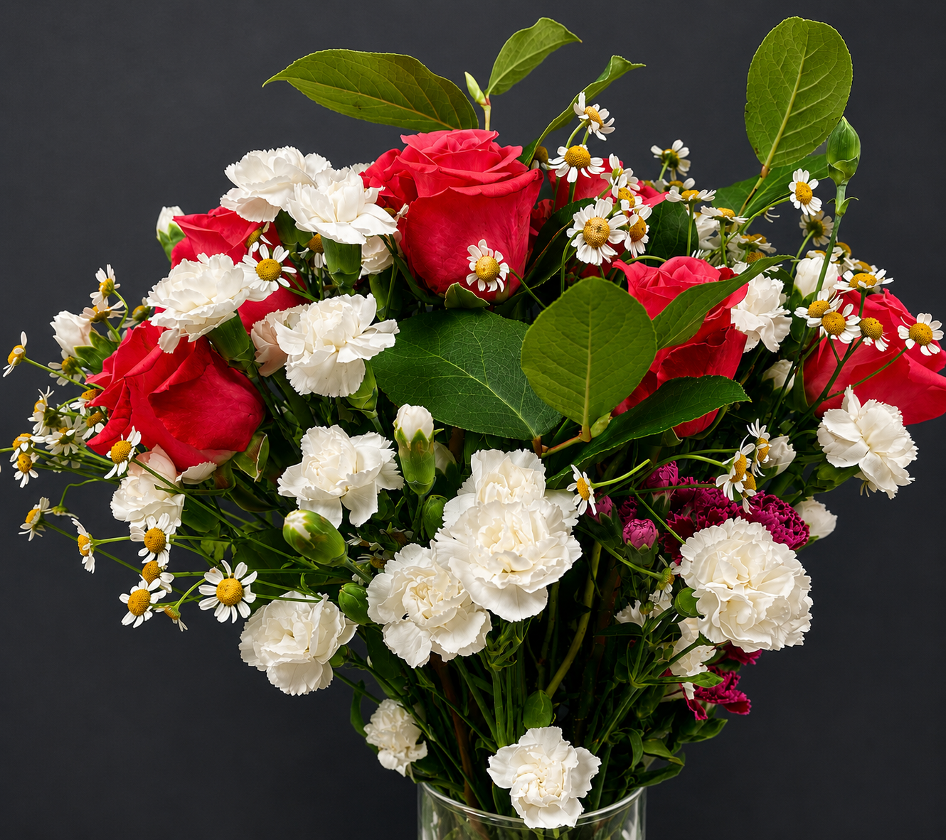 Custom floral arrangement featuring red roses, white carnations, delicate chamomile-like flowers, and fresh green foliage.