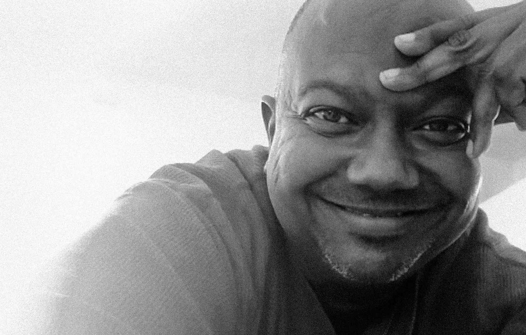 Black-and-white portrait of founder and executive director Jim Huntley smiling at the camera.