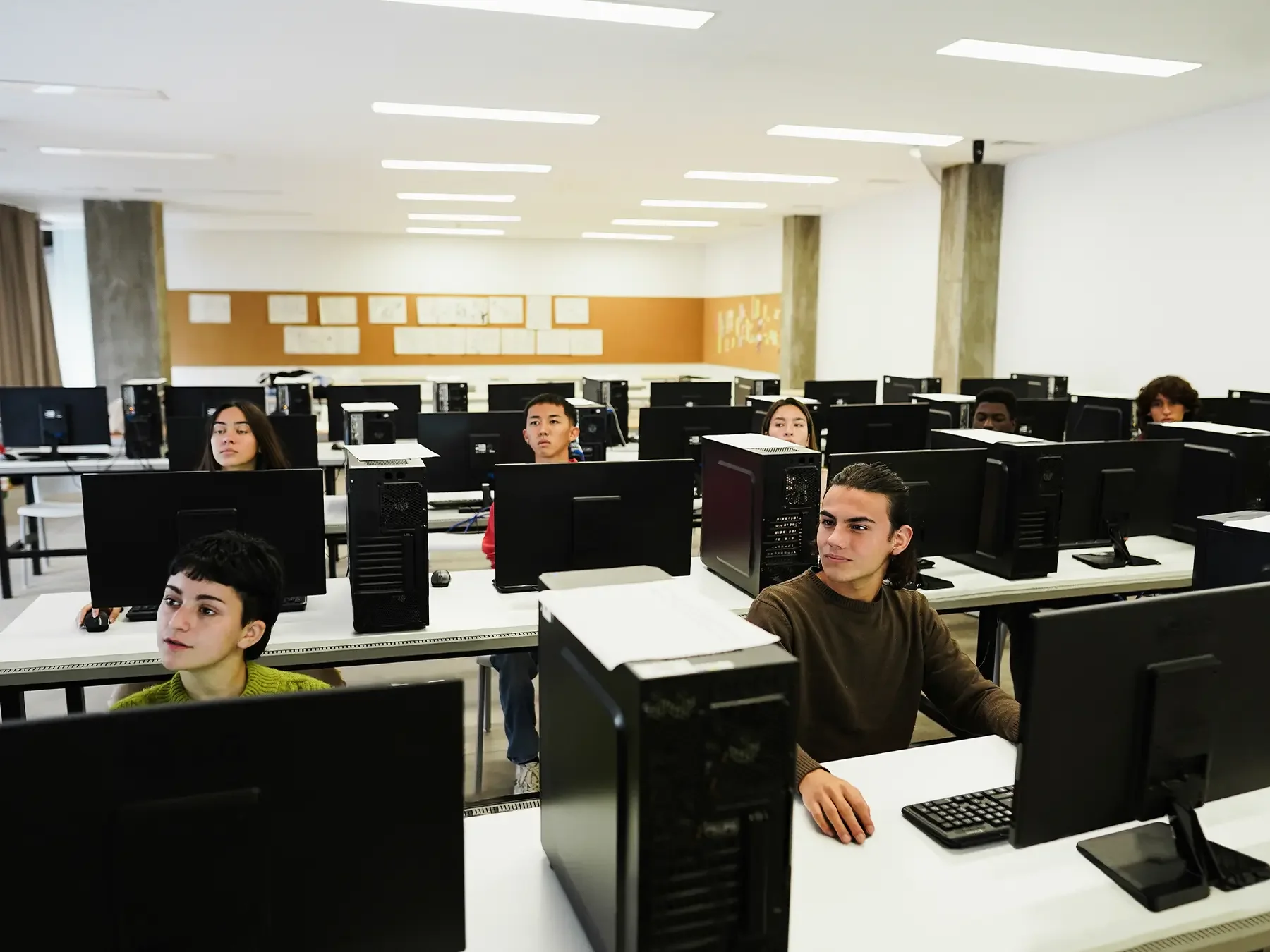 Middle and high school students learning computer programming in a classroom technology lab