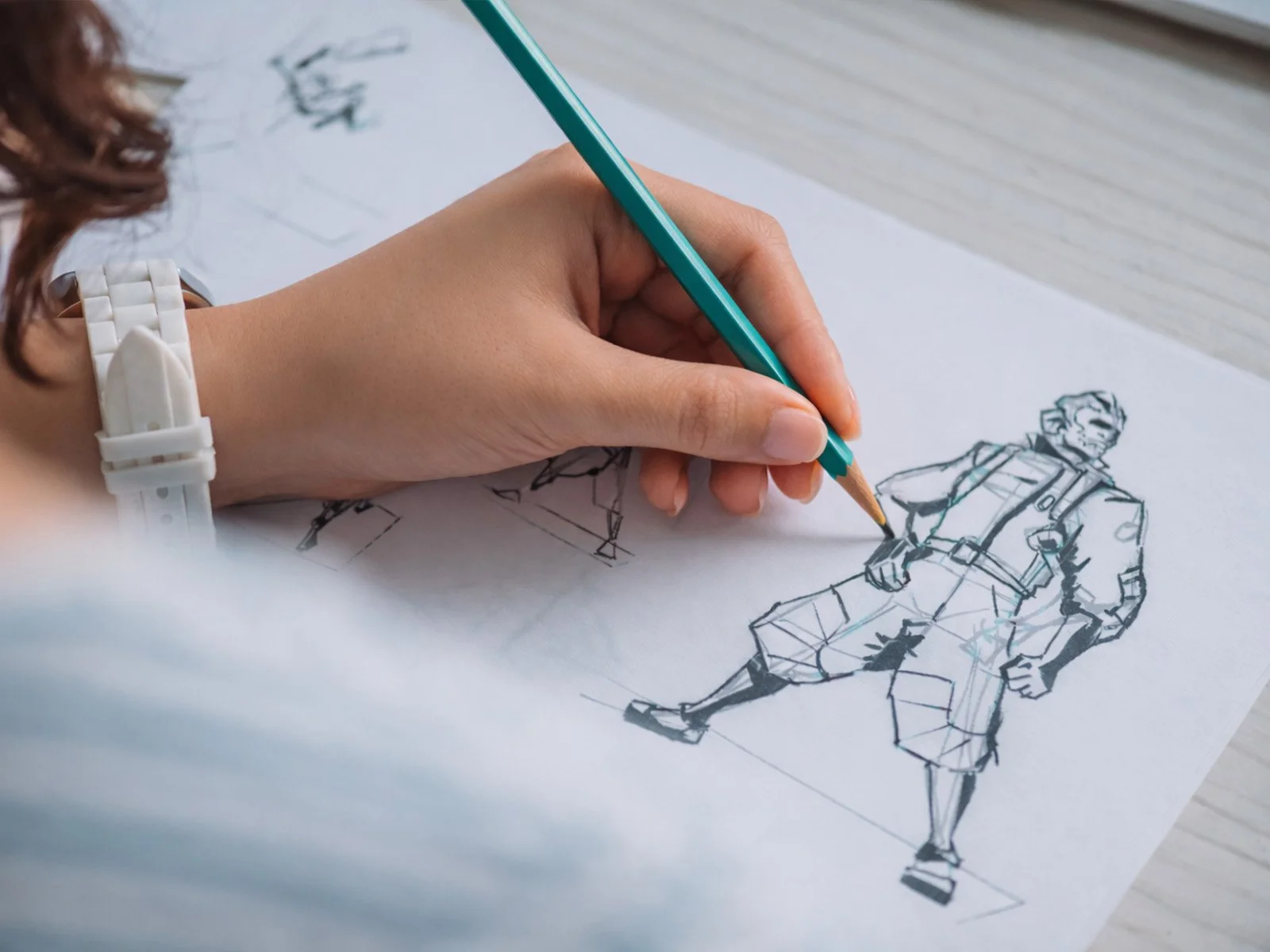 Student sketching a game character design on paper as part of a creative technology program.
