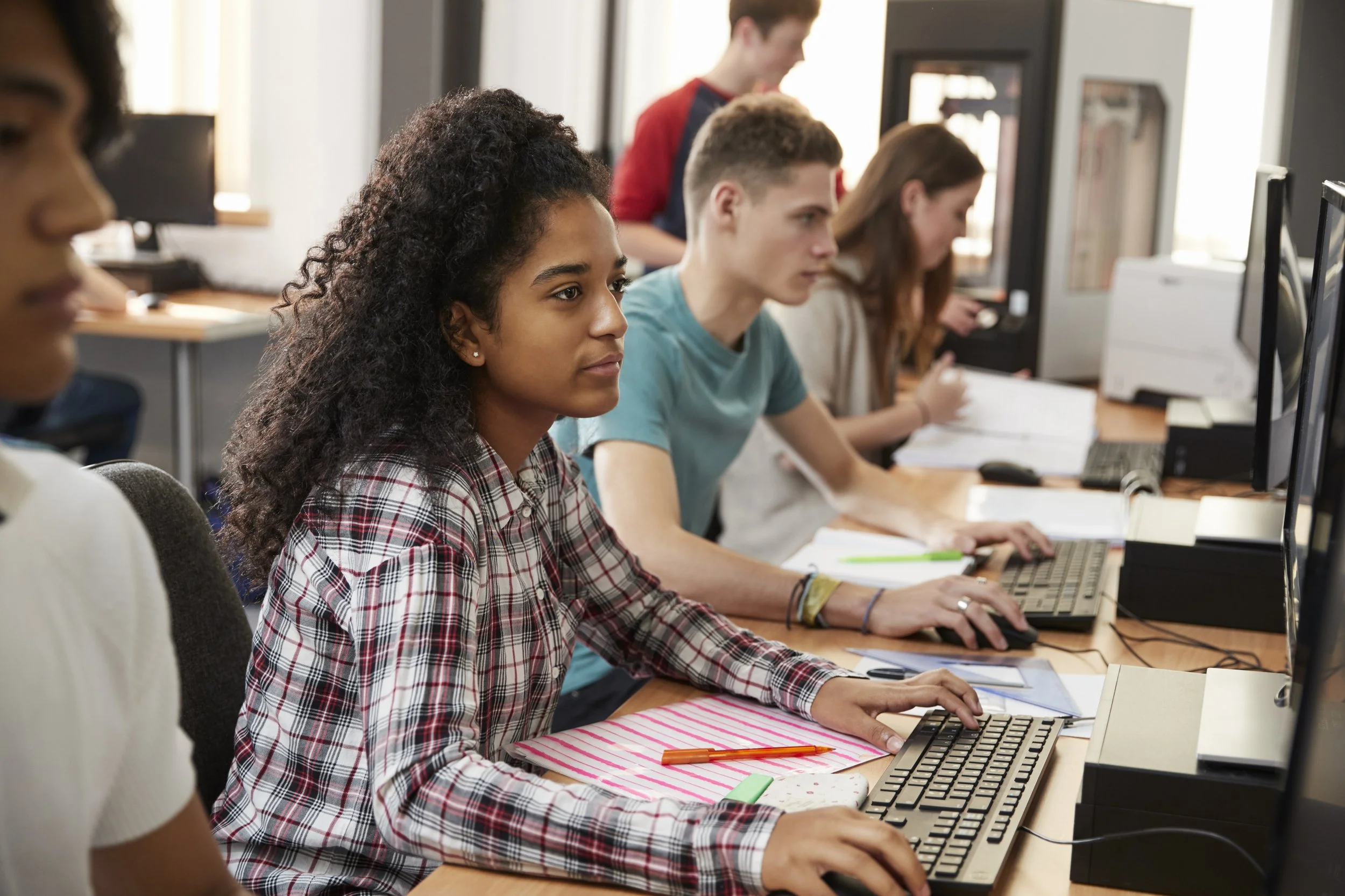 College student in a computer lab working at a desktop computer, representing inclusive game development and publishing education.
