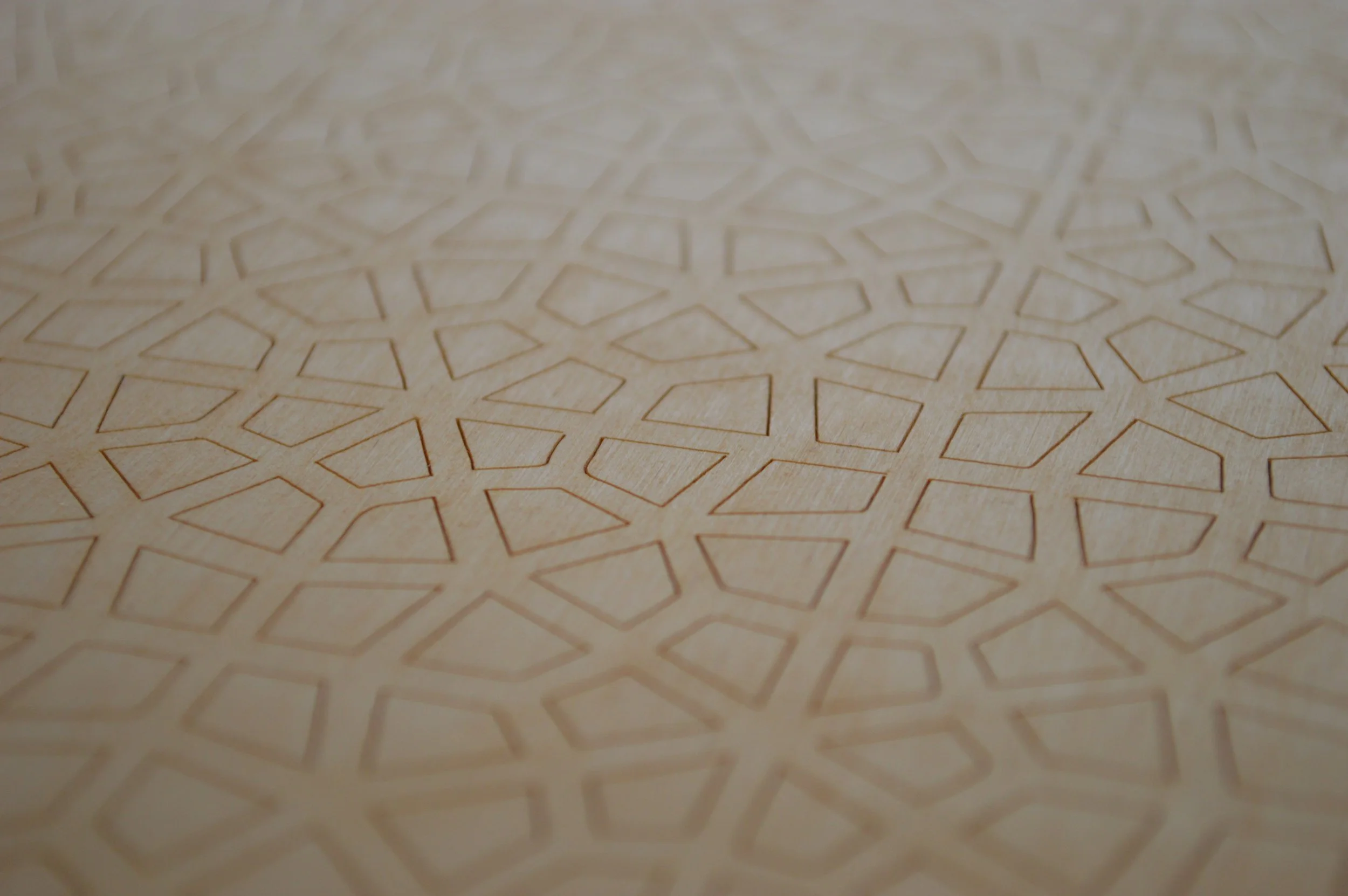 Close-up of a surface with geometric etched patterns resembling interconnected polygons.