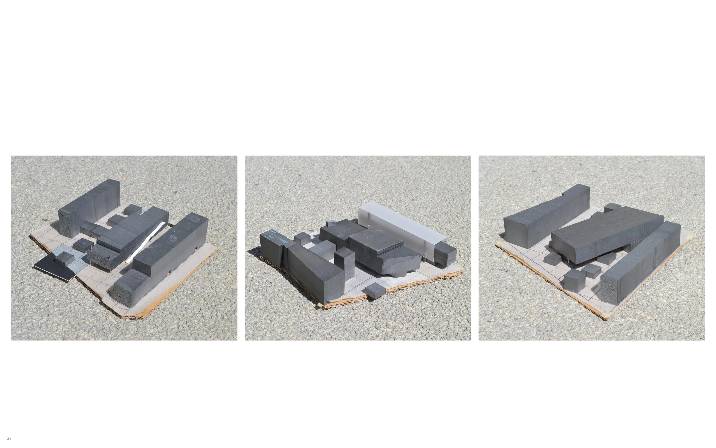 Three separate models of buildings made from gray foam or cardboard, each placed on a flat surface with a paper or cardboard base, photographed from different angles.