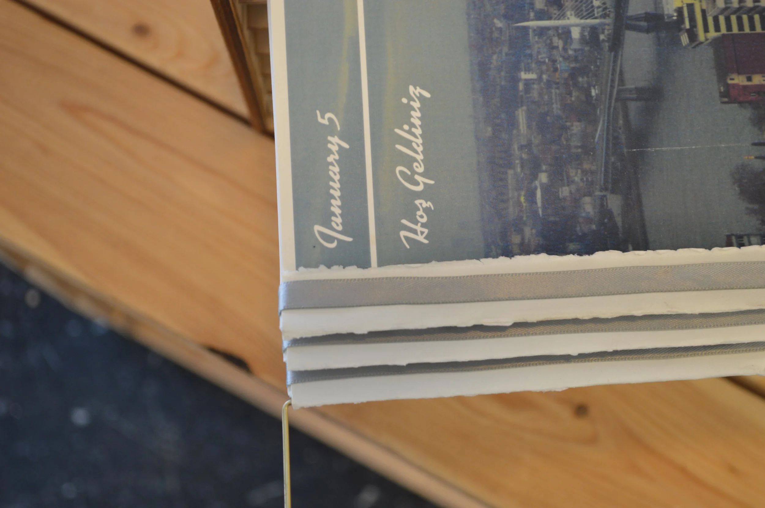 Books stacked on a wooden surface with a partial view of a glass display case and a printed cover that reads 'Townsend 5' and 'Foothills'.