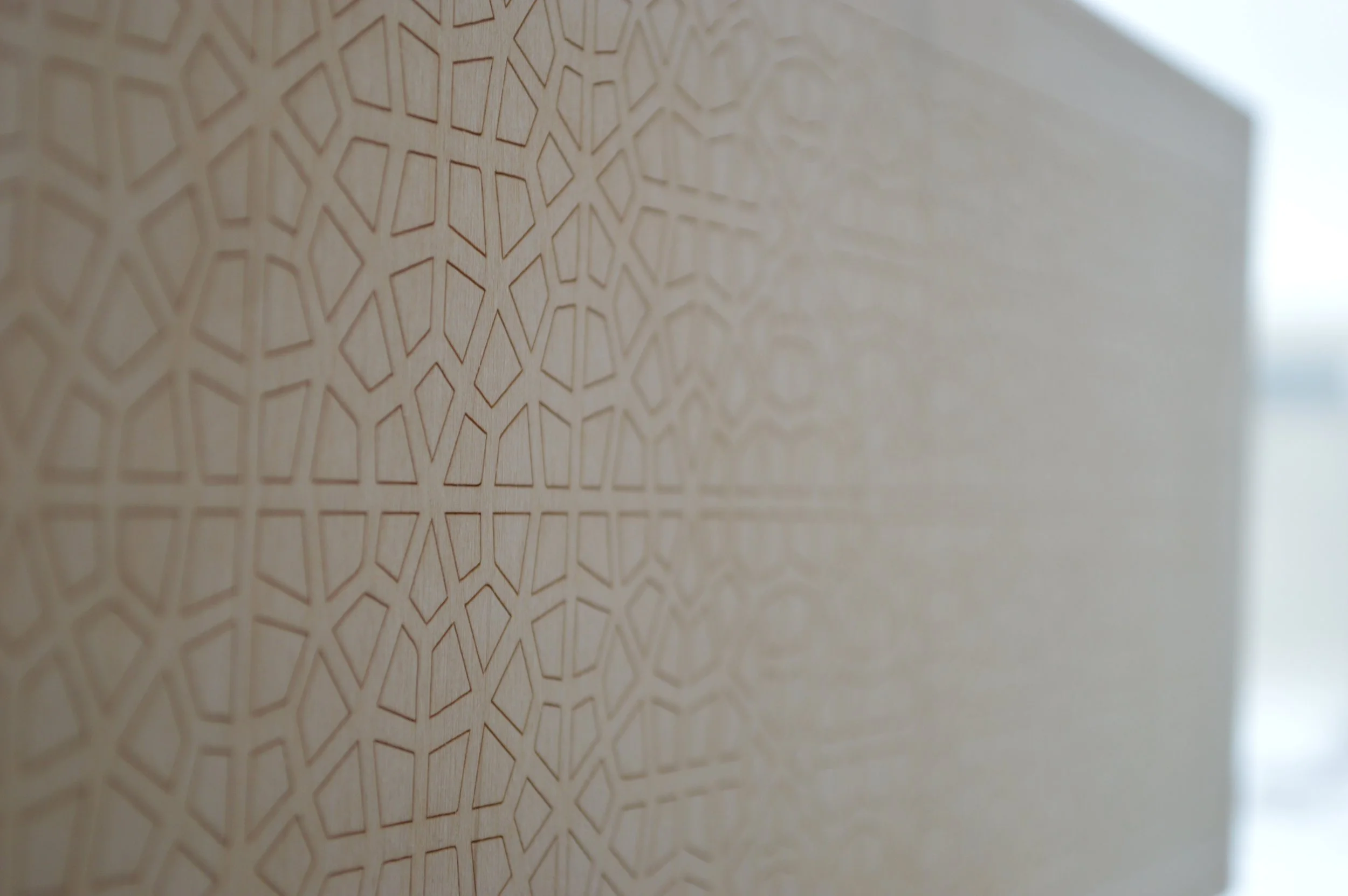 Close-up of a wooden surface with an intricate geometric pattern carved into it.