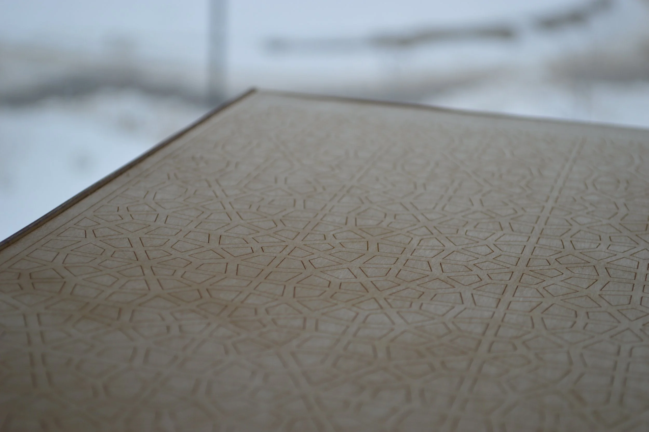 Close-up of a textured beige surface with a geometric pattern, with a blurred background.