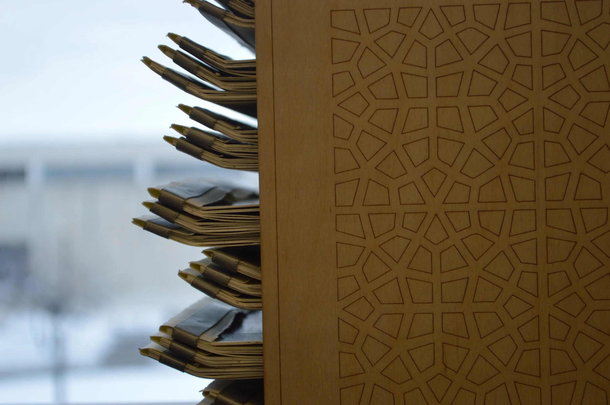 Stacked paper napkins or cloths with a geometric pattern background on a table.