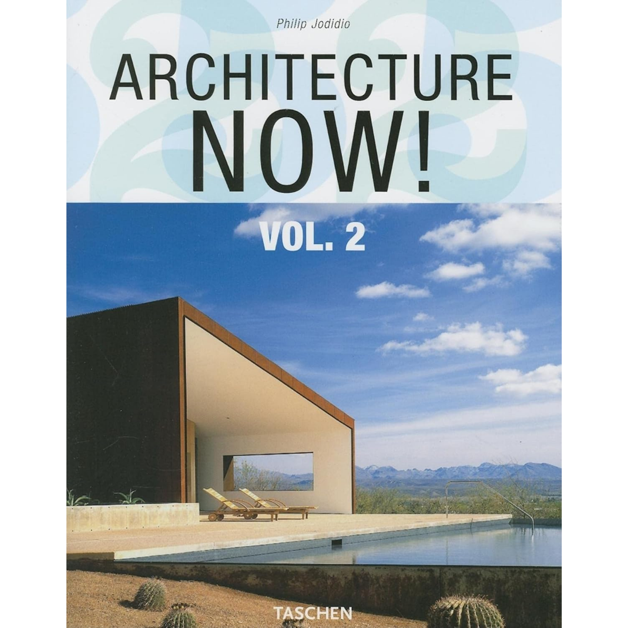 Book cover titled 'ARCHITECTURE NOW! VOL. 2' by Philip Jodidio, with a background of a blue sky and clouds, and a modern building with desert landscape including cacti in the foreground.