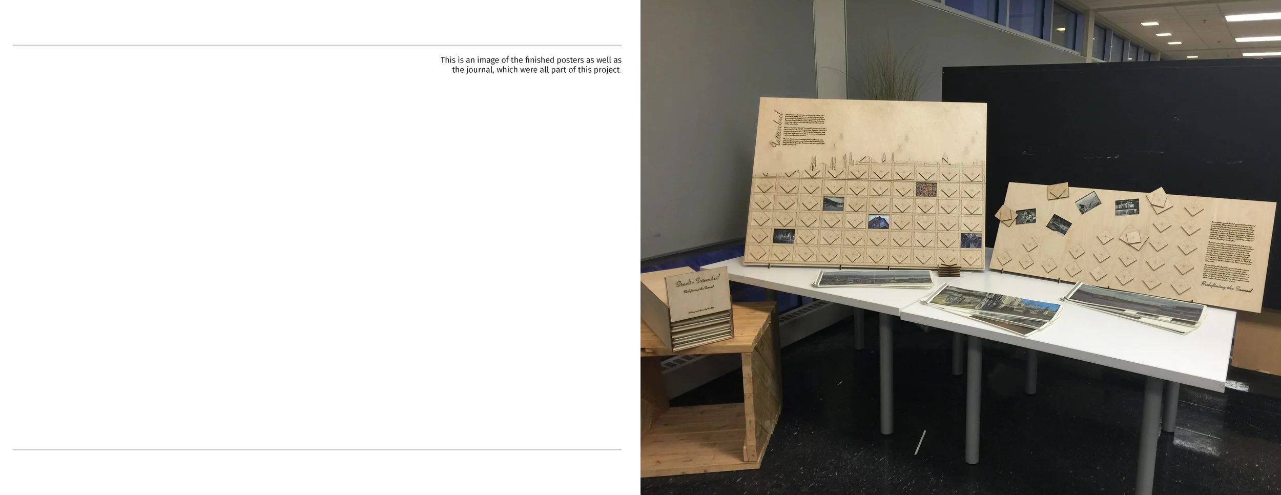 Exhibition display with poster boards, photographs, and informational text on a table in an indoor gallery.