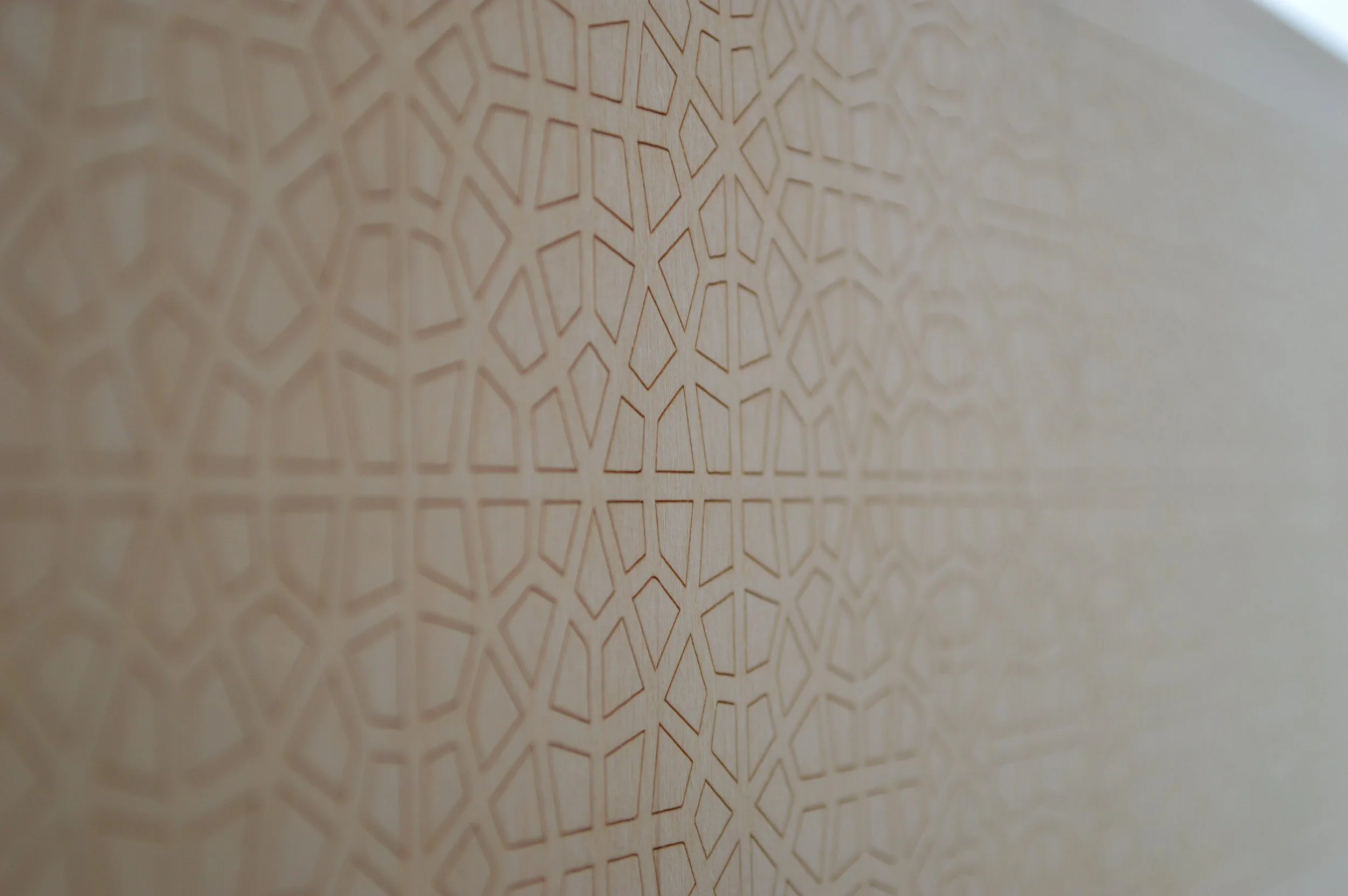 Close-up of a wooden surface with an intricate geometric pattern carved into it.
