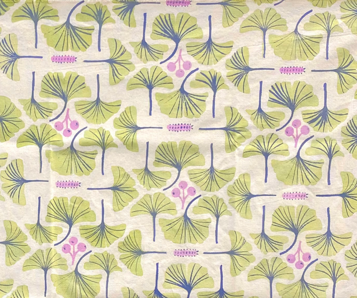 A patterned fabric featuring green ginkgo leaves with blue veins and pink berries on a light background.