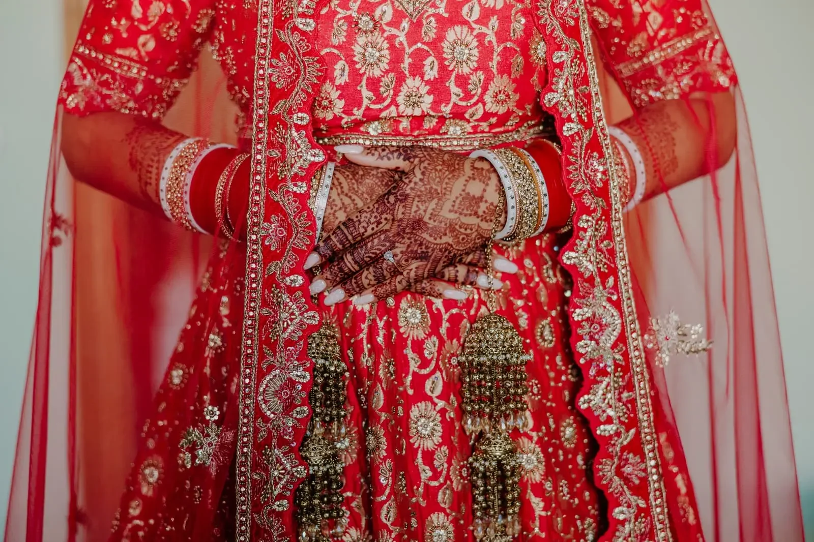 Elegant portrait of a Hindu bride in traditional red wedding attire with detailed mehndi and bridal jewelry during a luxury Indian destination wedding in Sicily, Italy.