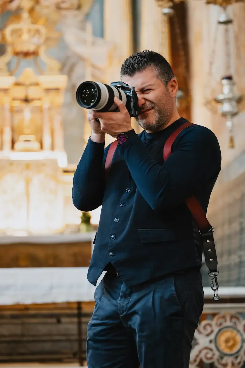 Wedding videographer filming a ceremony inside a baroque church in Ragusa Ibla, Sicily