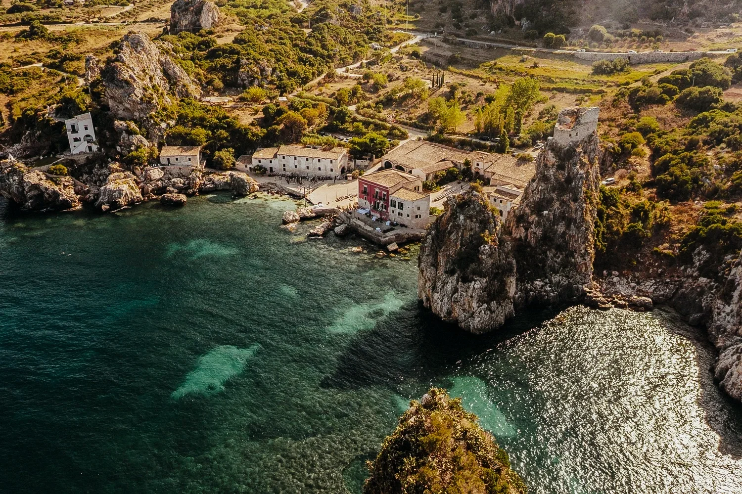 Luxury destination wedding at Tonnara di Scopello in Sicily, Italy, couple overlooking the sea with iconic faraglioni and Mediterranean landscape