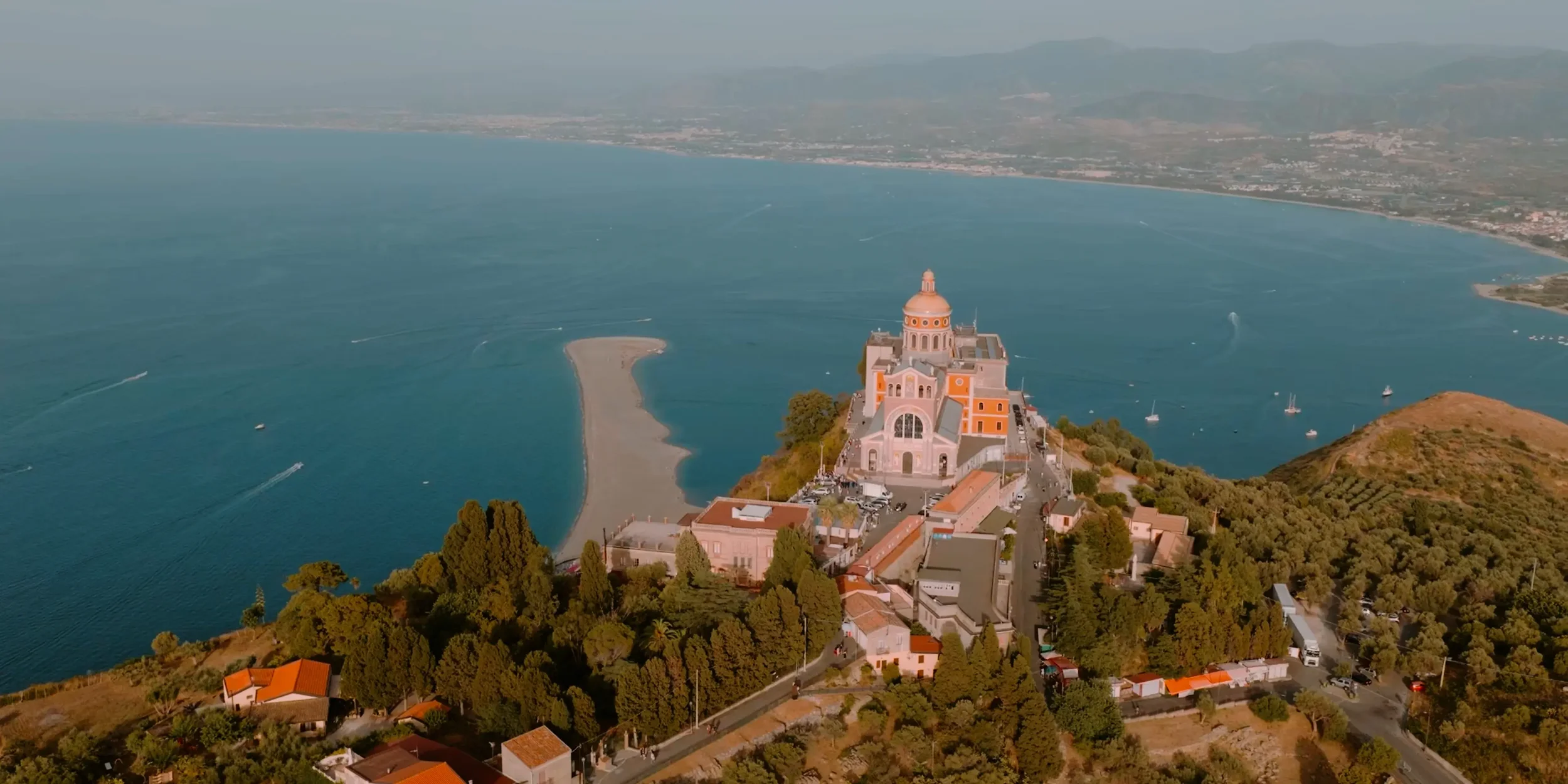 Aerial drone view of the Santuario di Tindari overlooking the Marinello Lagoons during Giann Luke and Roberta’s destination wedding ceremony in Sicily, Italy.