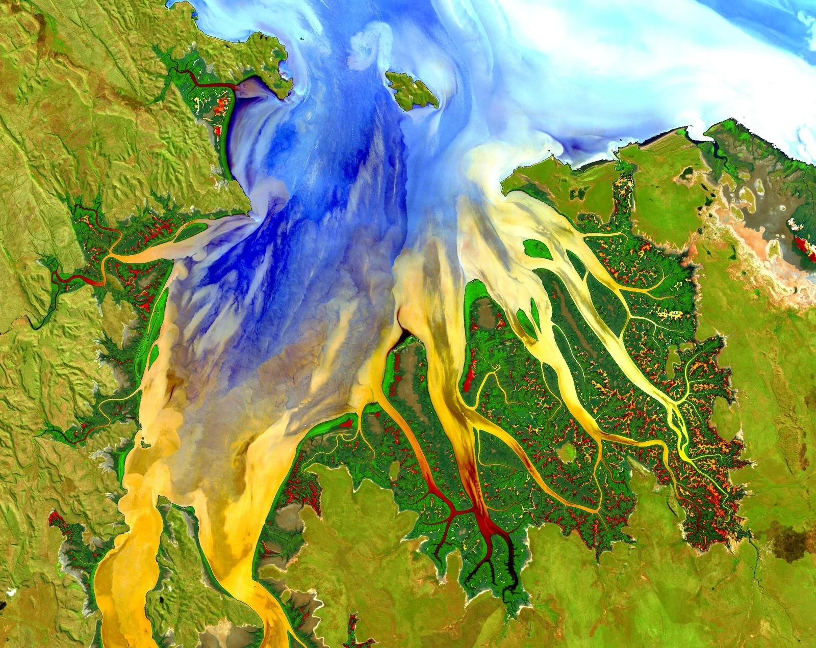 Colorful satellite image of a large body of water with a dam creating a reservoir, showing water flow and surrounding terrain with roads, vegetation, and land formations.