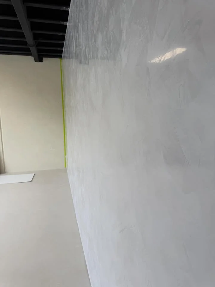 Empty room with white floor, beige wall, corner with yellow tape, ceiling with black beams.
Stucco Mirror like finish Venetian Plaster Mornington Peninsula