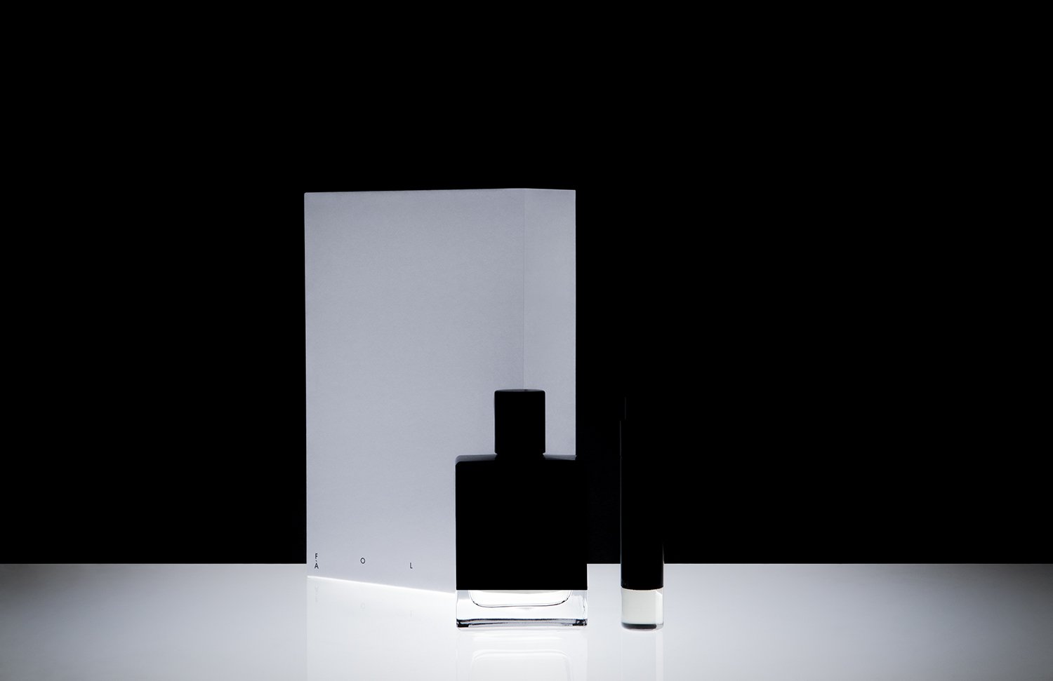 Minimalist black and white perfume bottles with a white backdrop, different shapes and sizes, with the word 'FALOL' partially visible on the left
