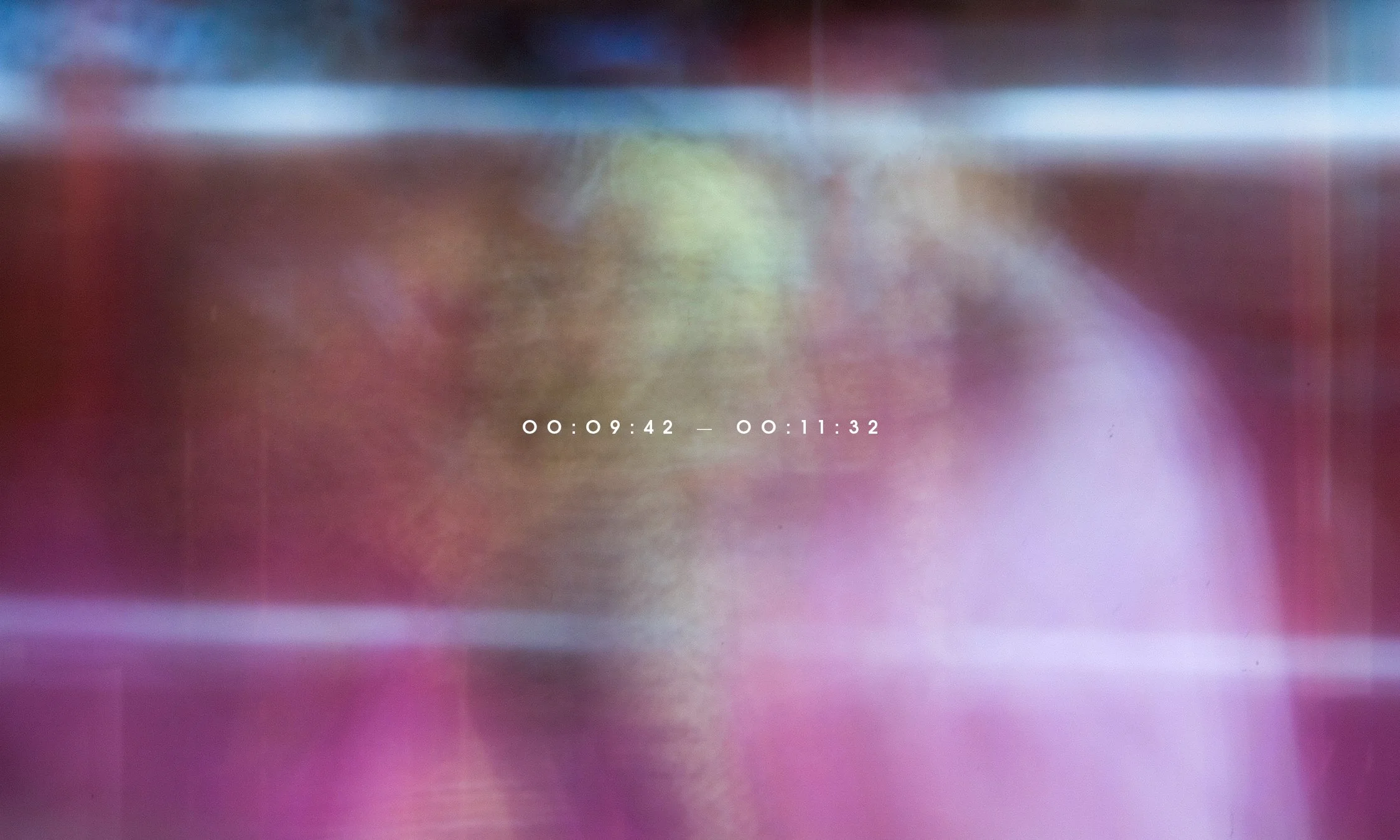 Blurred image with pink, purple, and yellow colors, overlaid with white text showing timestamps.