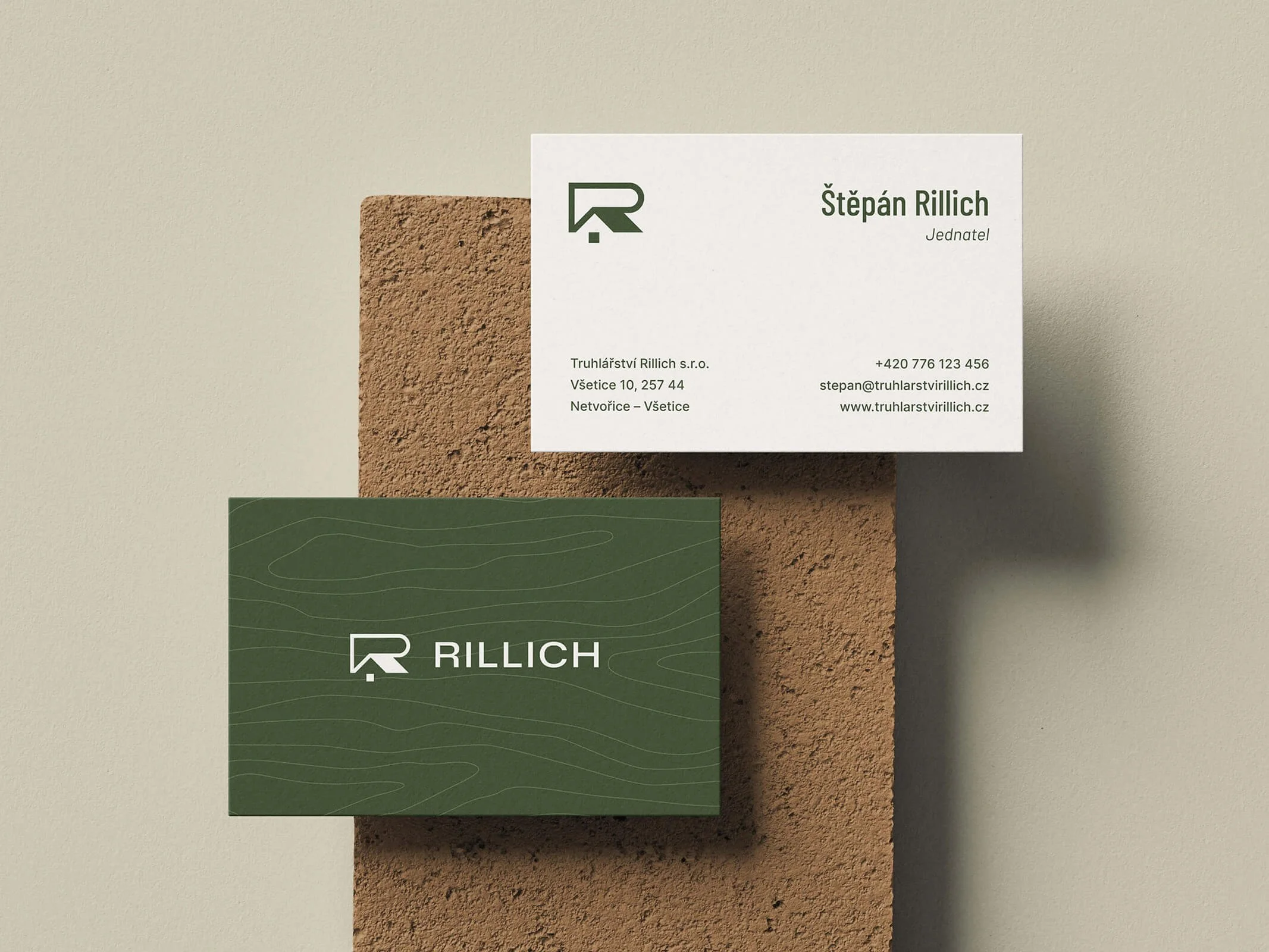 Vizitky značky Rillich na cihlovém pozadí.