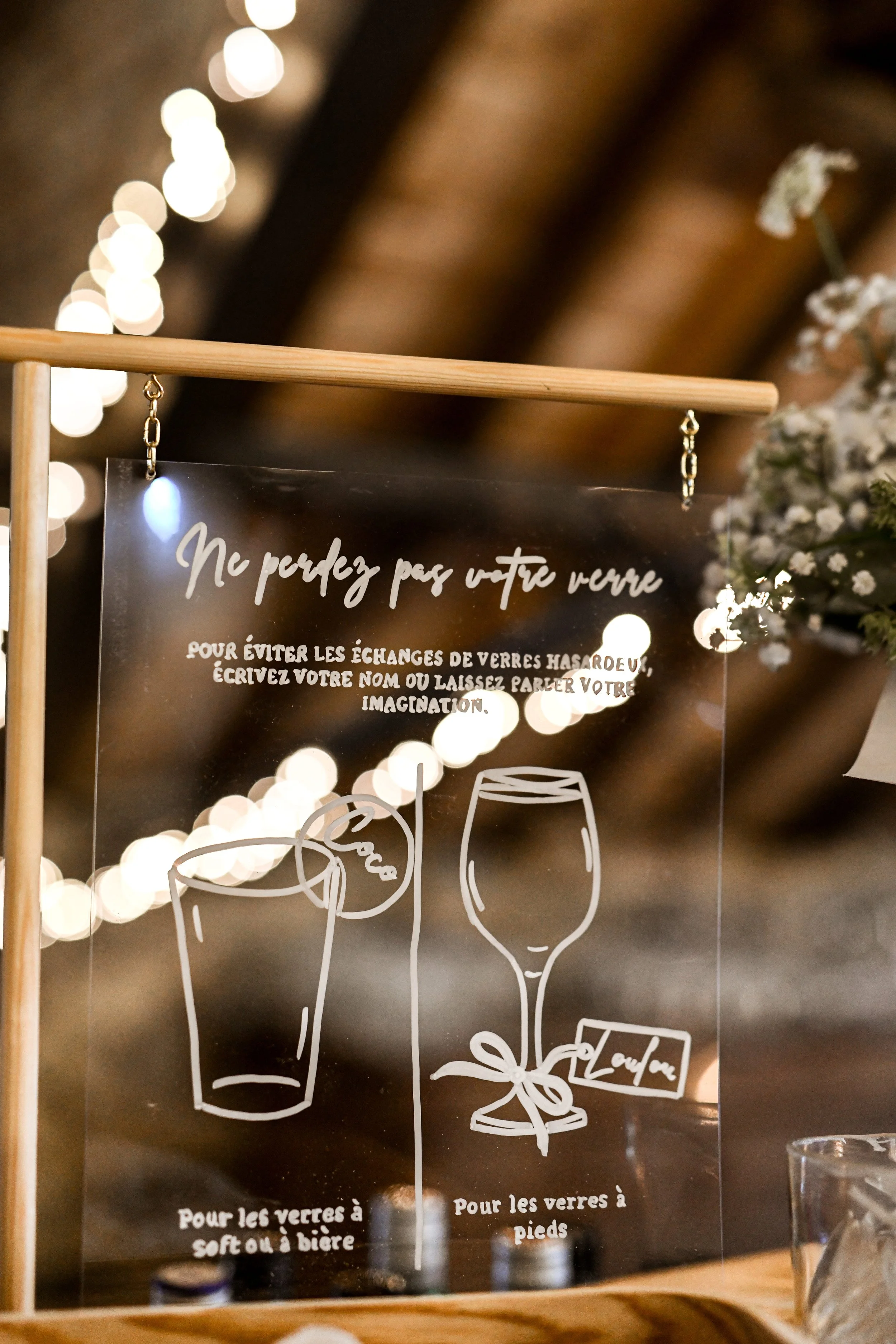  panneau en acrylique avec instructions pour éviter les échanges de verre lors d'événements, avec dessins de verres à vin et à cocktail, et texte en français.