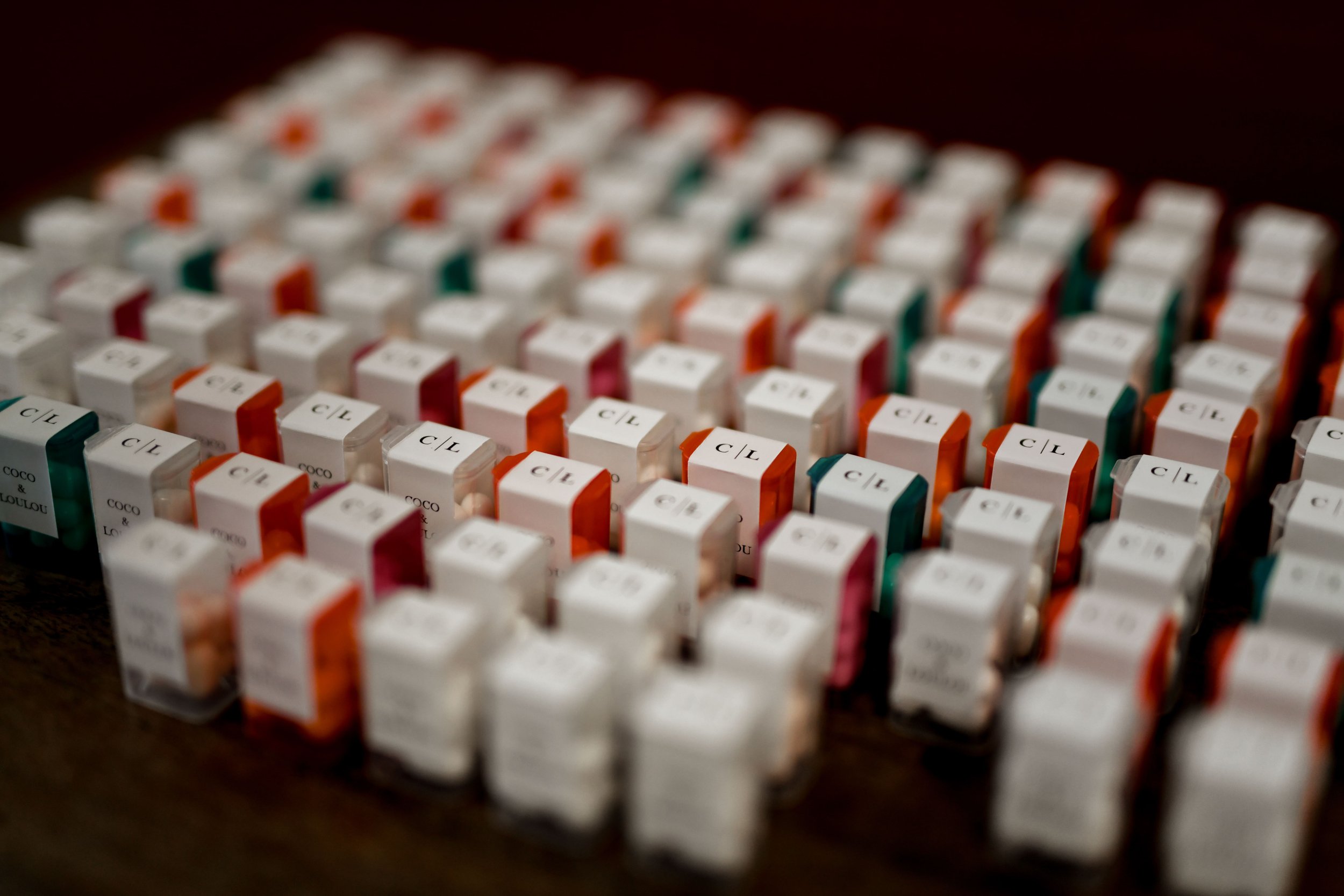 Blocs de bonbons blancs, orange, verts et roses sur une surface sombre.