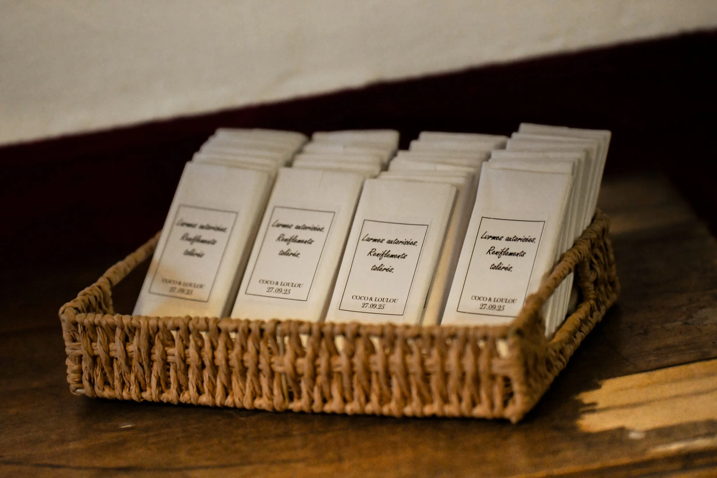Un panier en osier contenant plusieurs petits papiers ou cartes, avec des textes en français.