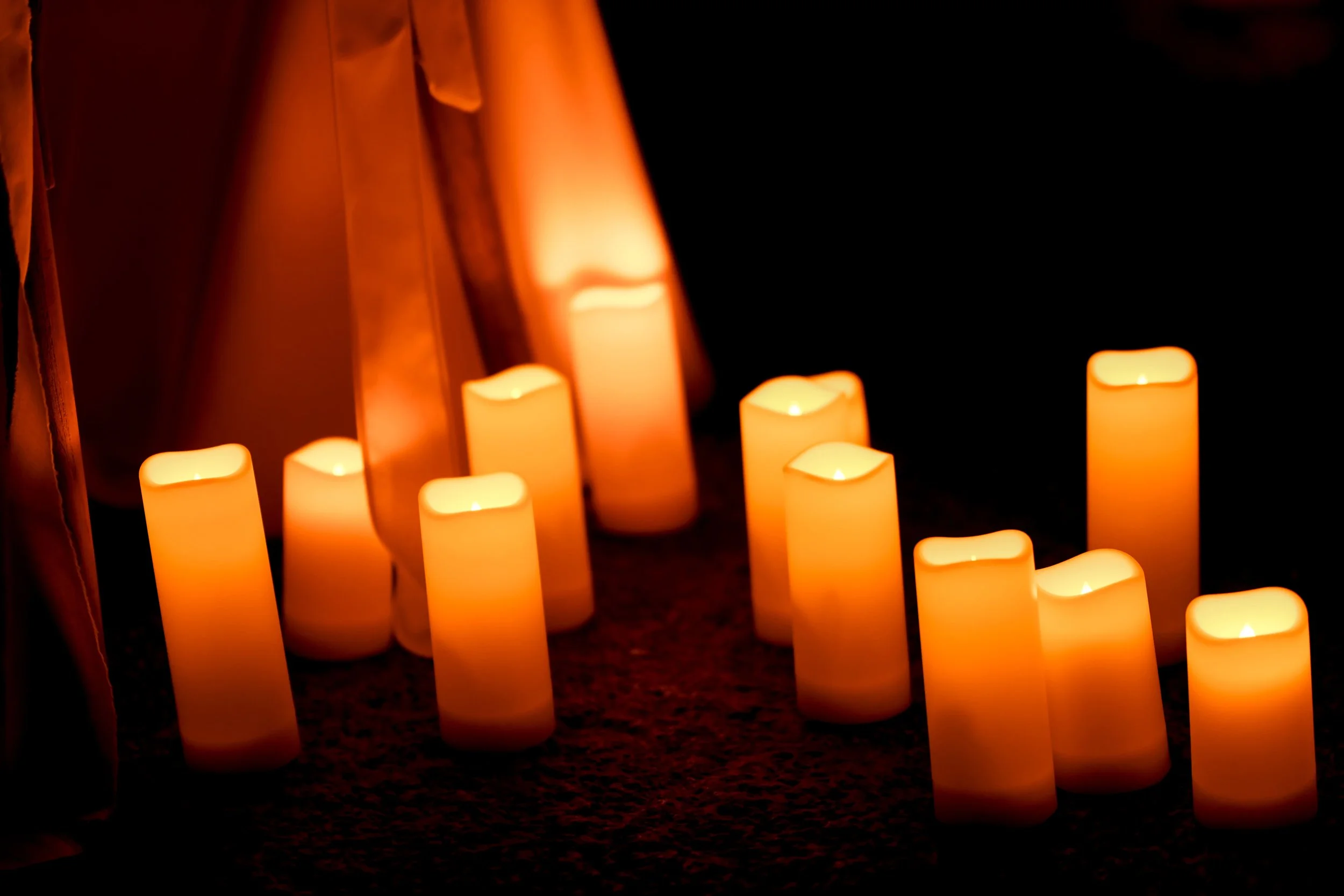Bougies allumées sur une surface sombre, créant une ambiance chaleureuse et apaisante.