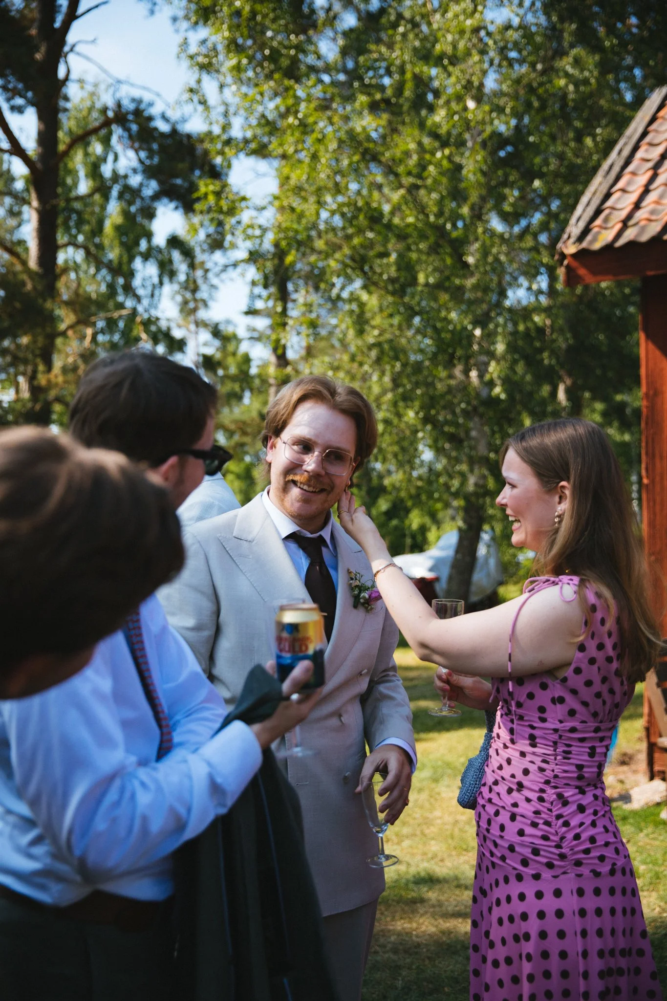 Brudgum och gäster skrattar tillsammans efter vigsel. 