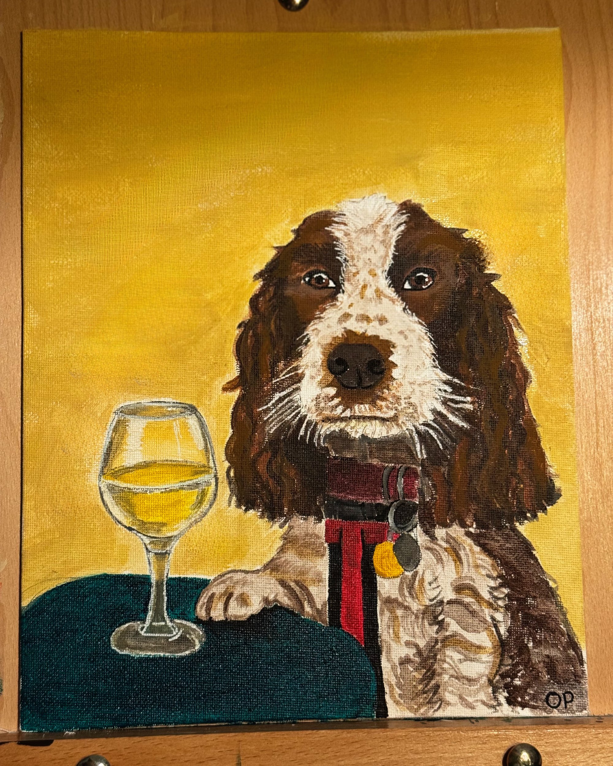 Finished custom pet portrait of a spaniel with a glass of white wine, displayed on a wooden easel