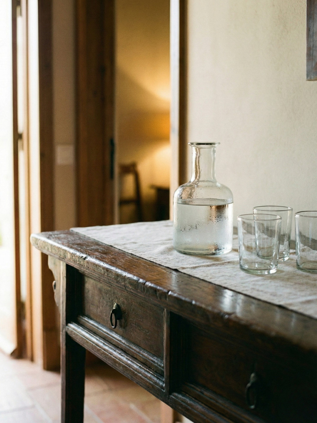 Glaskaraffe und Wassergläser auf Sideboard