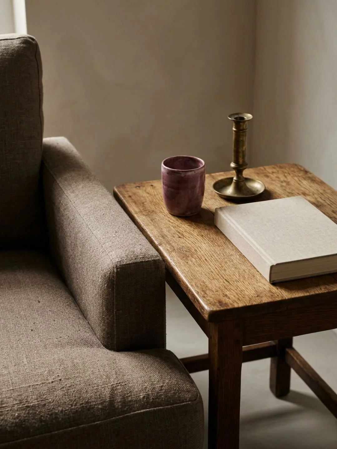 Sietable with a book, mug und candlestick holder next to chair