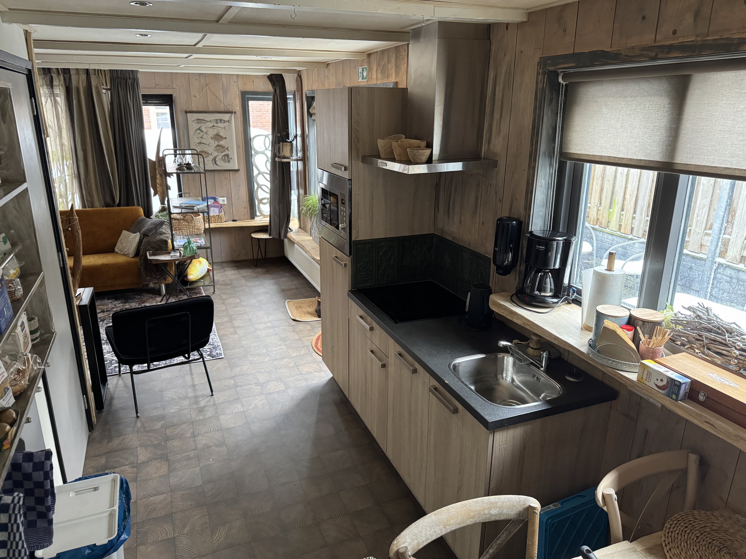 praktische keuken met zitruimte in het appartement van de B&B, voorzien van keukenblad, wasbak en eettafel, met uitzicht op de tuin en directe verbinding met de woonruimte.