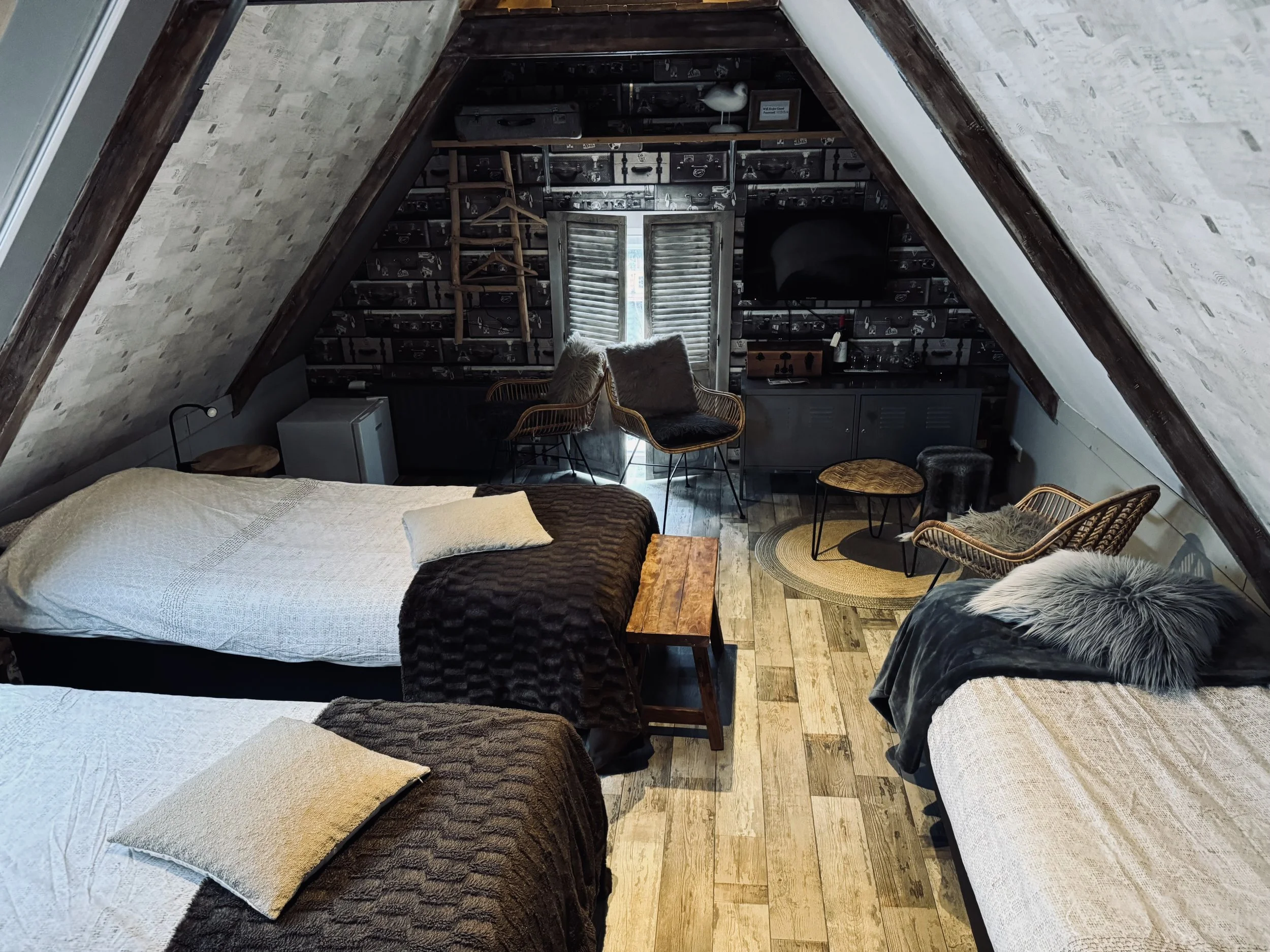 Ruime 3-persoonskamer op de bovenverdieping van de B&B met drie eenpersoonsbedden, zithoek en karakteristieke balken onder het schuine dak, sfeervol en comfortabel ingericht.