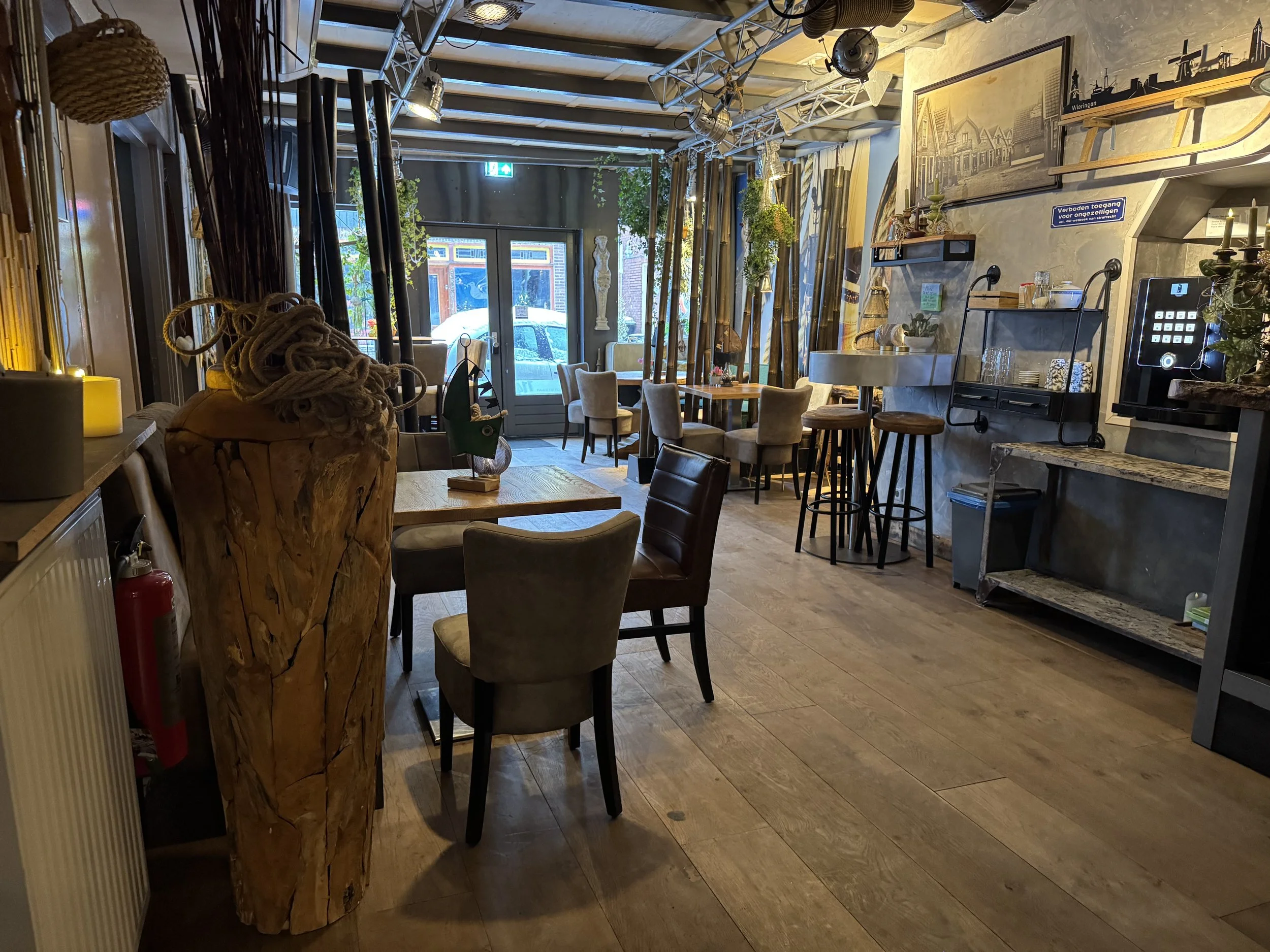 Ruime en sfeervolle gemeenschappelijke ruimte in de B&B met eettafels, zithoeken en bar, ingericht met natuurlijke materialen en geschikt om te ontbijten of samen te ontspannen.