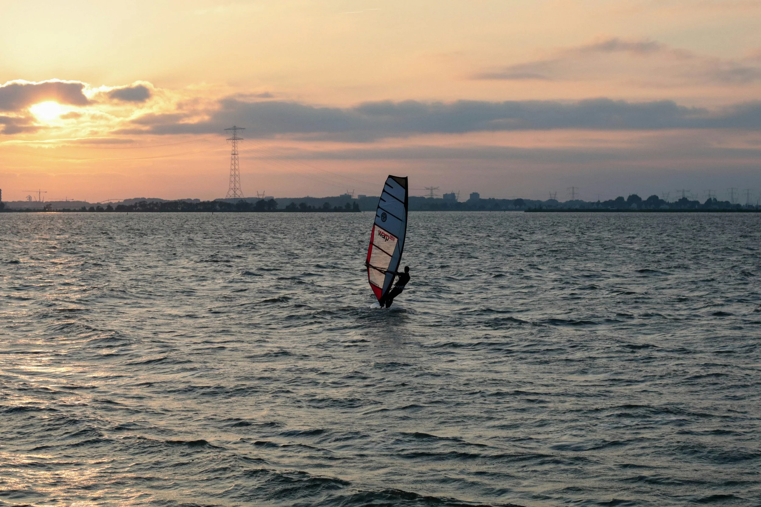 een persoon aan het windsurfen op het water
