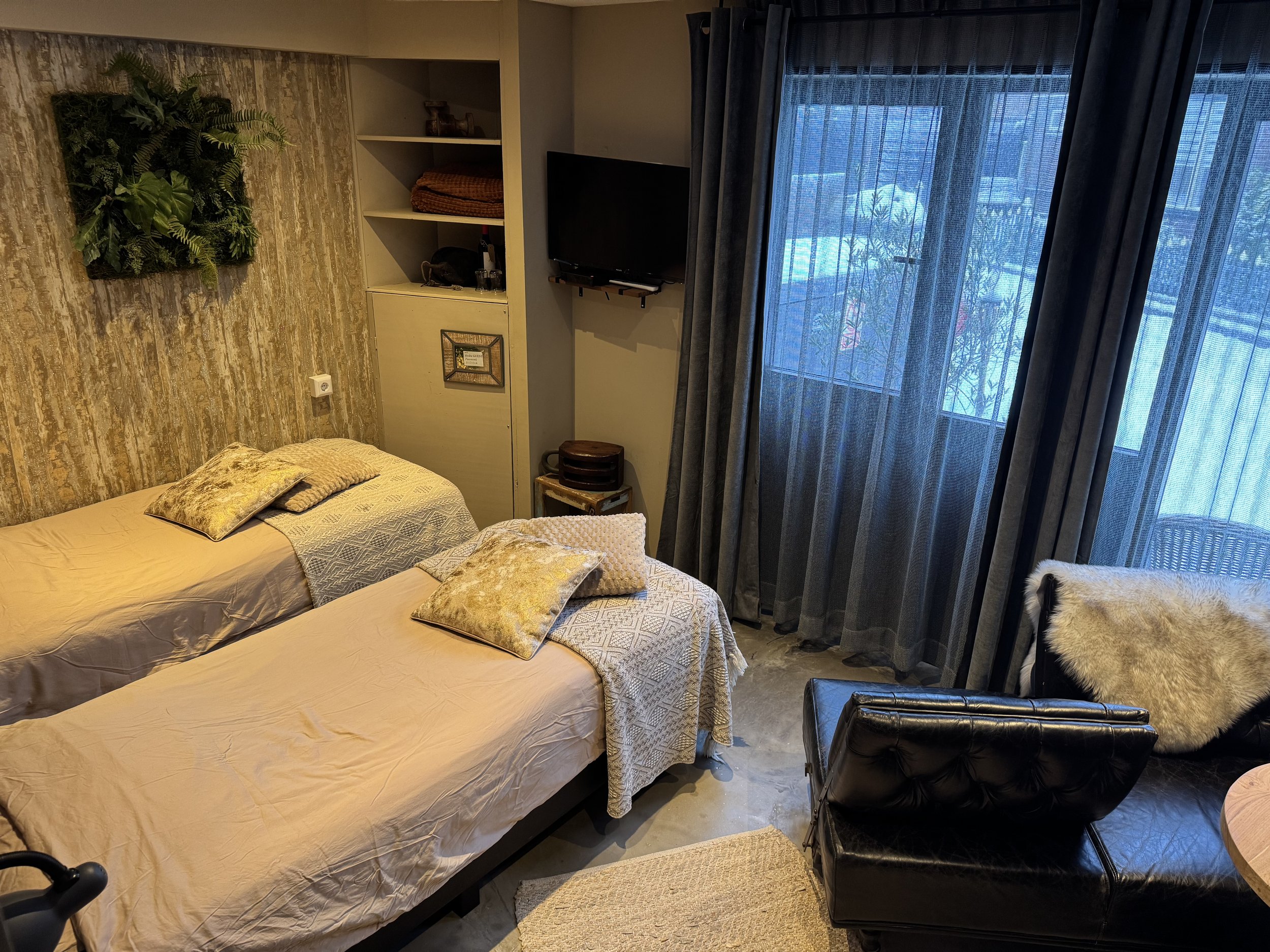 Comfortabele 2-persoonskamer in de B&B met twee eenpersoonsbedden, zitstoel en veel daglicht, sfeervol ingericht met zachte stoffen en warme kleuren voor een rustige en ontspannen overnachting