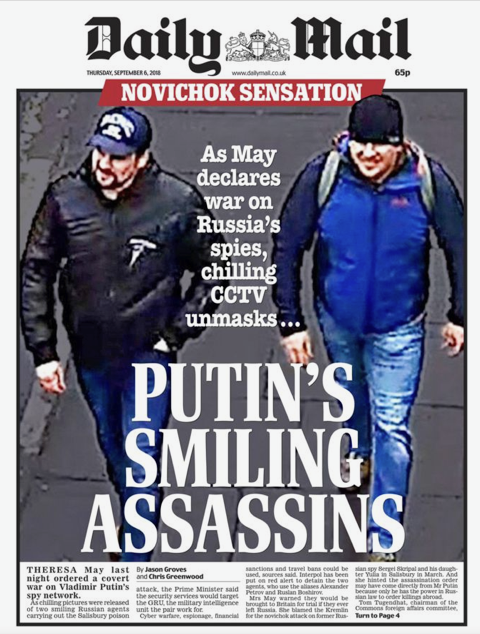 Front page of Daily Mail newspaper with headline "Putin's Smiling Assassins" and a photo of two men walking, one wearing a baseball cap and black jacket, the other in a blue jacket and black hat. The newspaper also mentions a declared war on Russia's spies and unmasking CCTV cameras.