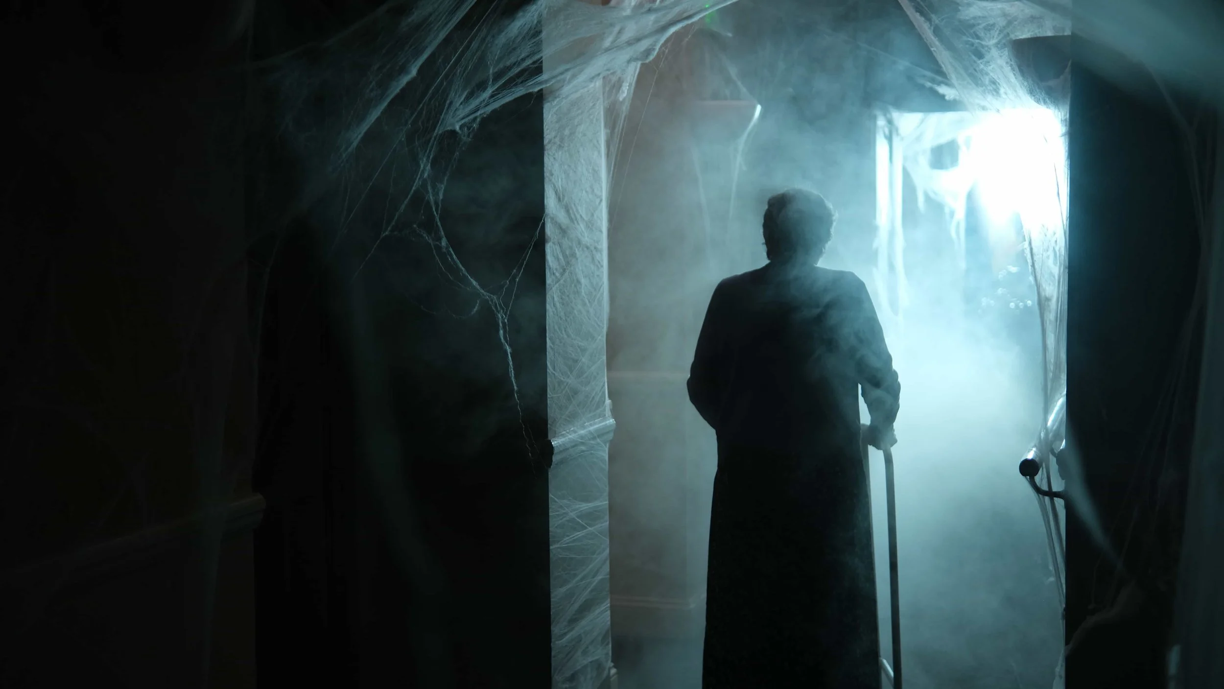 Behind the scenes of 'The Humbug' - a short film Directed by Cole Paviour.  An elderly woman walking through a foggy, dimly lit corridor with cobwebs on the walls.