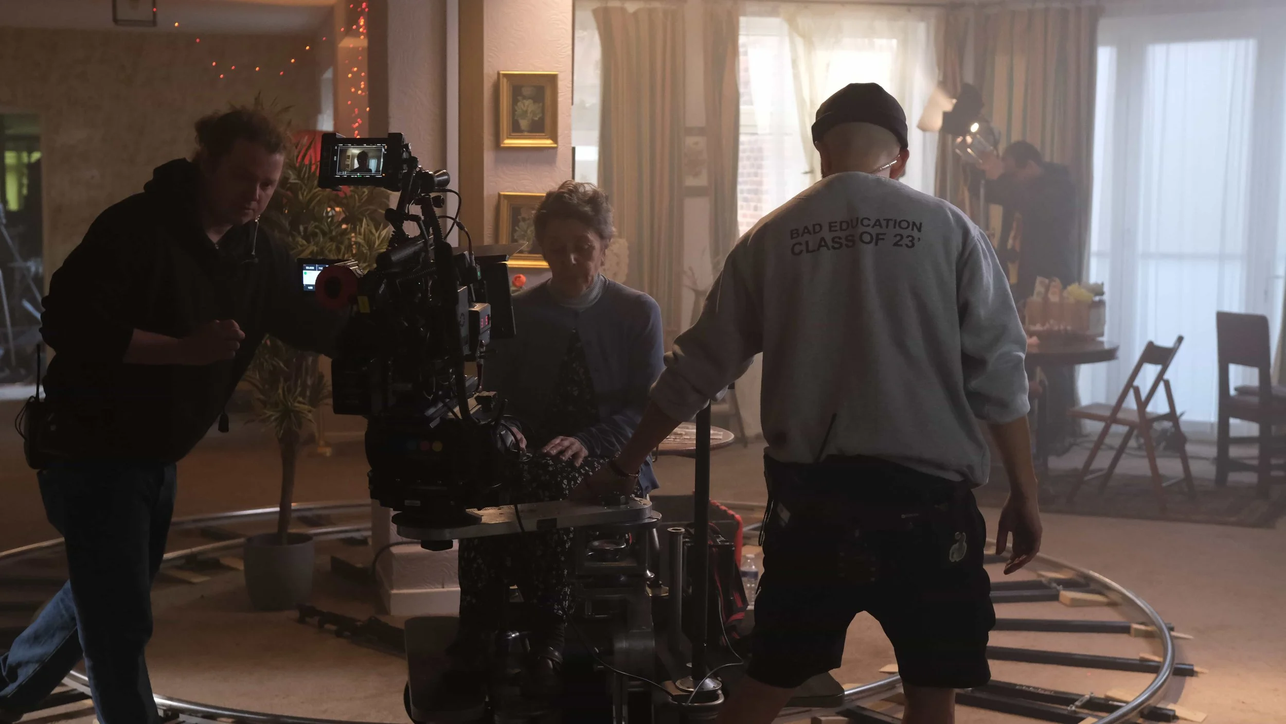 Behind the scenes of 'The Humbug' - a short film Directed by Cole Paviour. Film crew operating camera and equipment indoors with lead actress sitting in front of the camera.