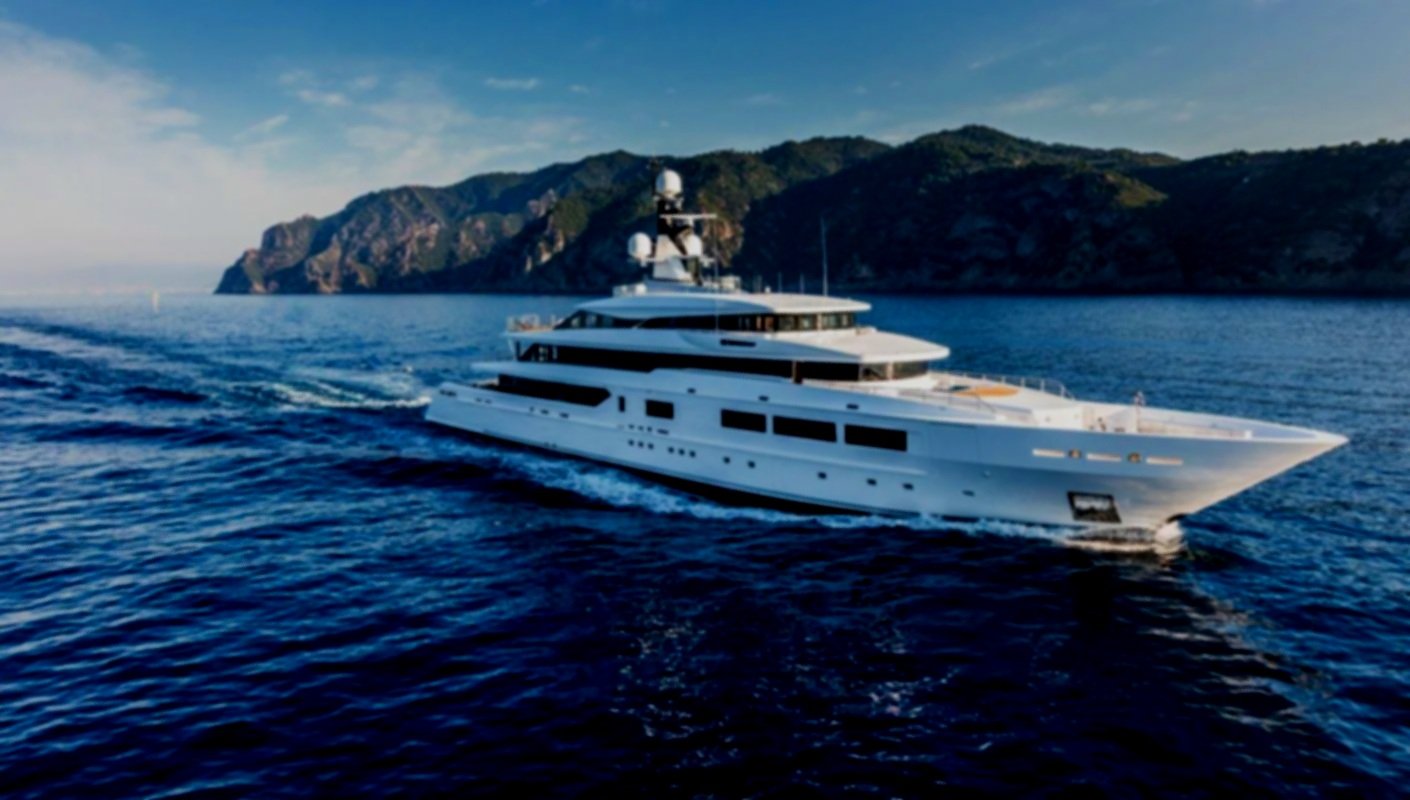 Luxury yacht charter in Mykonos anchored near coastline at sunset