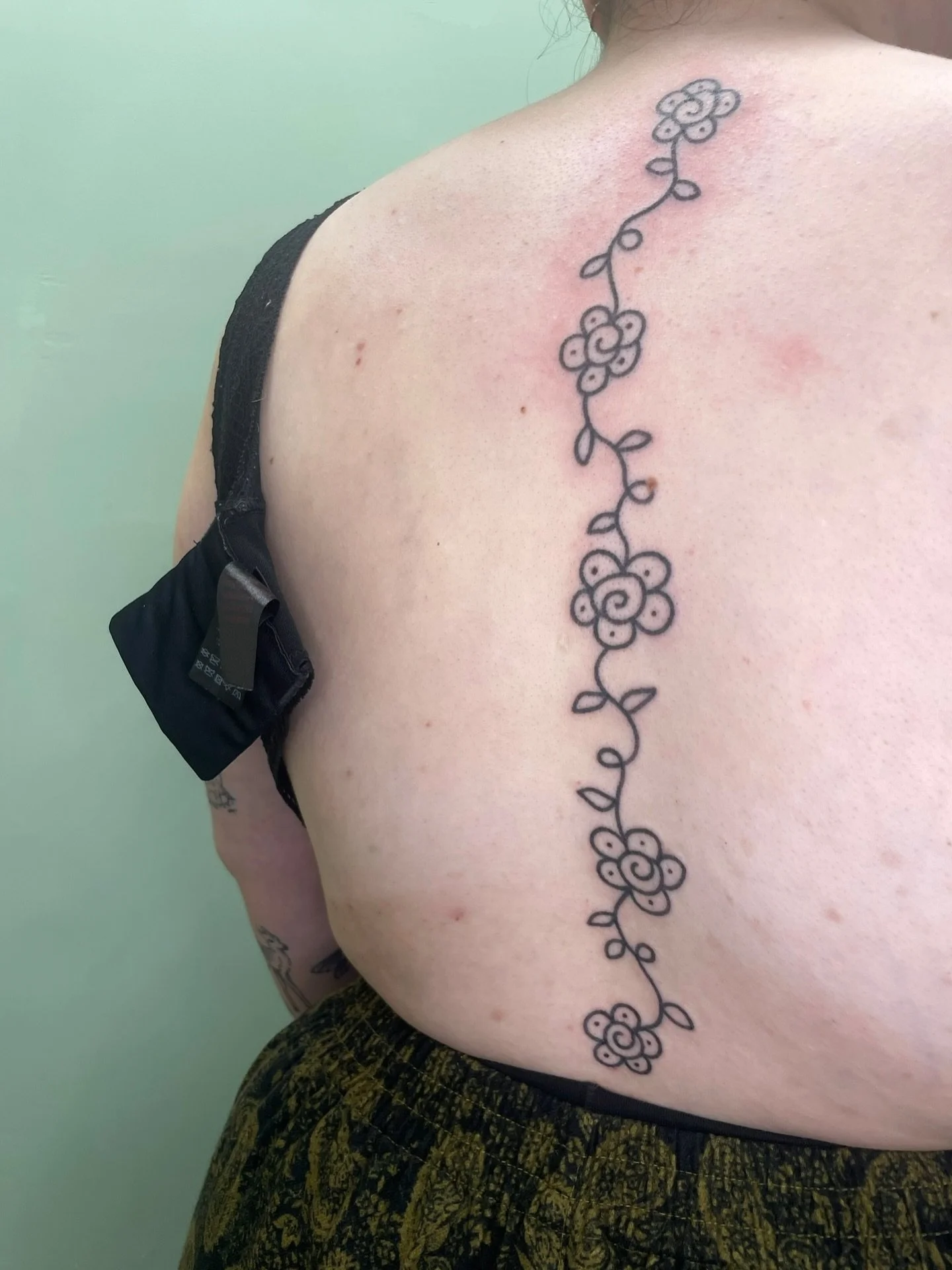 A bold and simple chain of flowers, hand poked for Erin 🌸

I love a spine placement, this design suited it perfectly!

#stickandpoke #handpoke