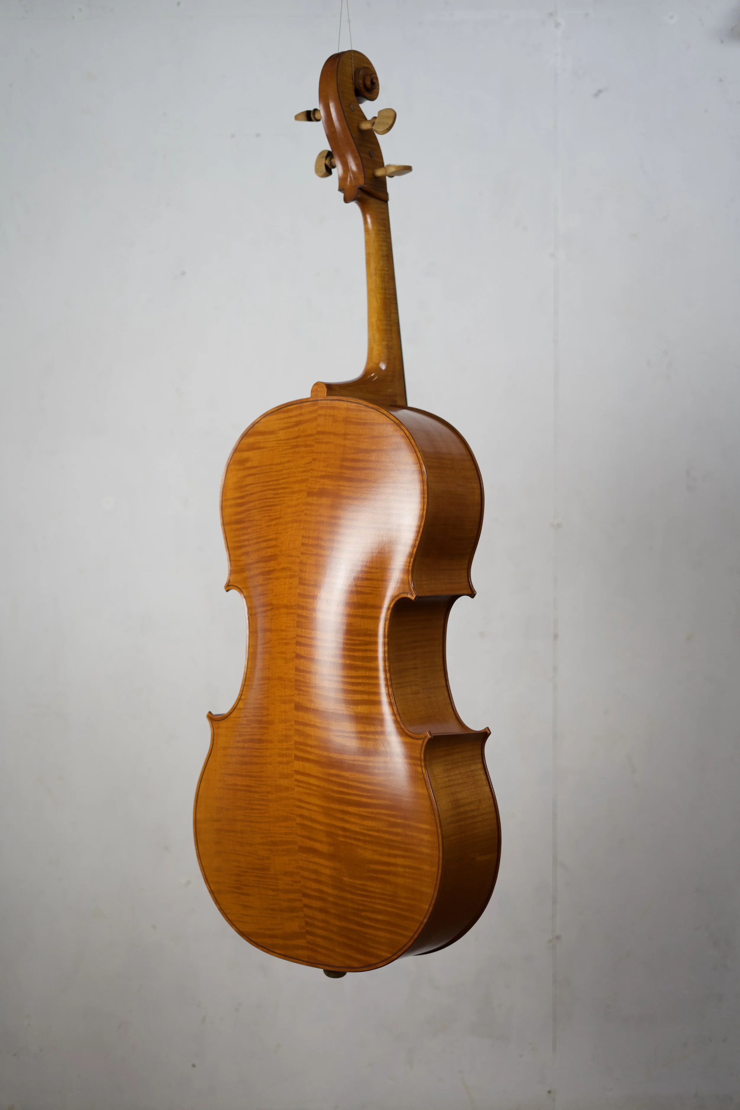 A wooden cello hanging on a wall.